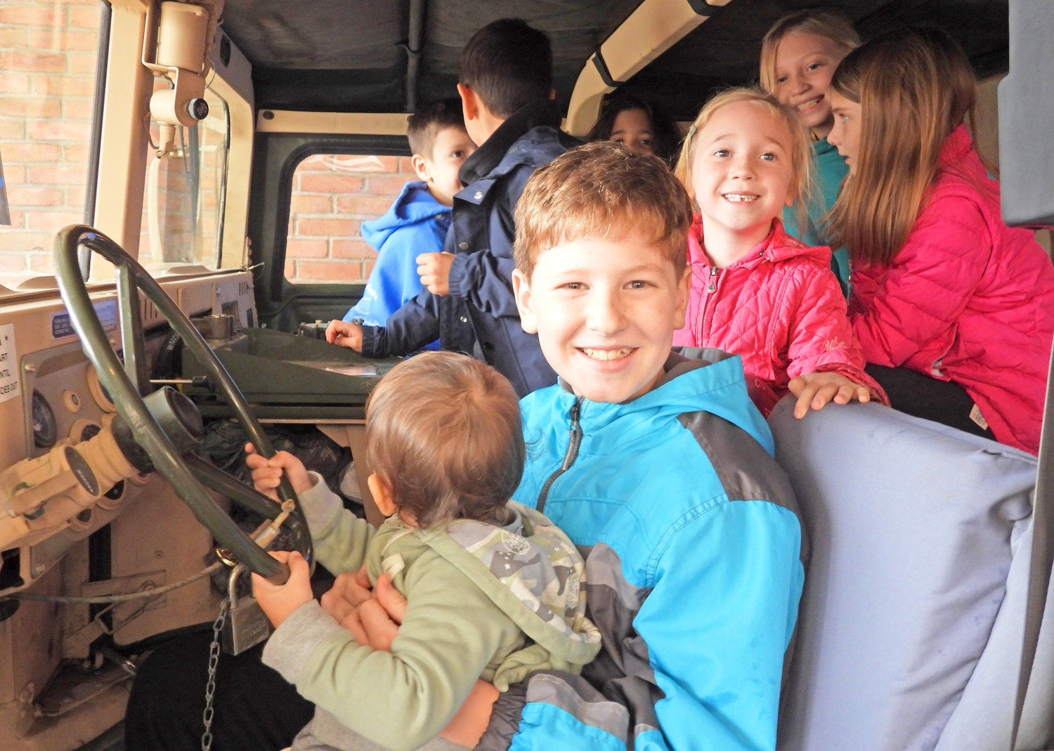 BEHIND THE WHEEL — A group of children get a turn in the driver’s seat of a military Humvee at the Redeemer Church, 129 N. Washington St., recently.