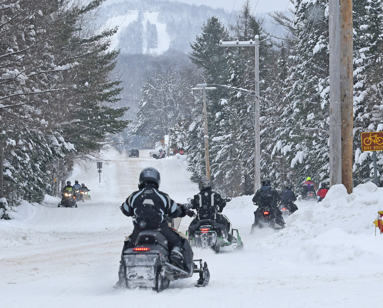 Snowmobiliers in the town of Webb travel down North Street, last year, toward the village of Old Forge with McCauley Mountain in the backgournd.