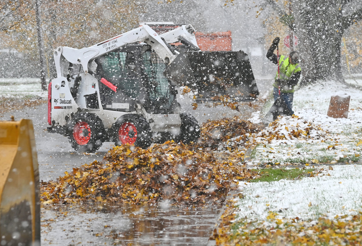 NO STOPPING — Workers with the city’s Department of Public Works stick to their task of picking up leaves amid some falling snow on Friday, Nov. 19, 2021, on Walnut Street.  With the snowfall light in Rome — although it was heavier elsewhere in the county — the department kept going with its annual bulk leaf collection.  If crews are needed for road clearing duties, officials said, they will temporarily halt leaf pickup to make sure roads are passable. Check out the gallery in the photo gallery section of the home page.