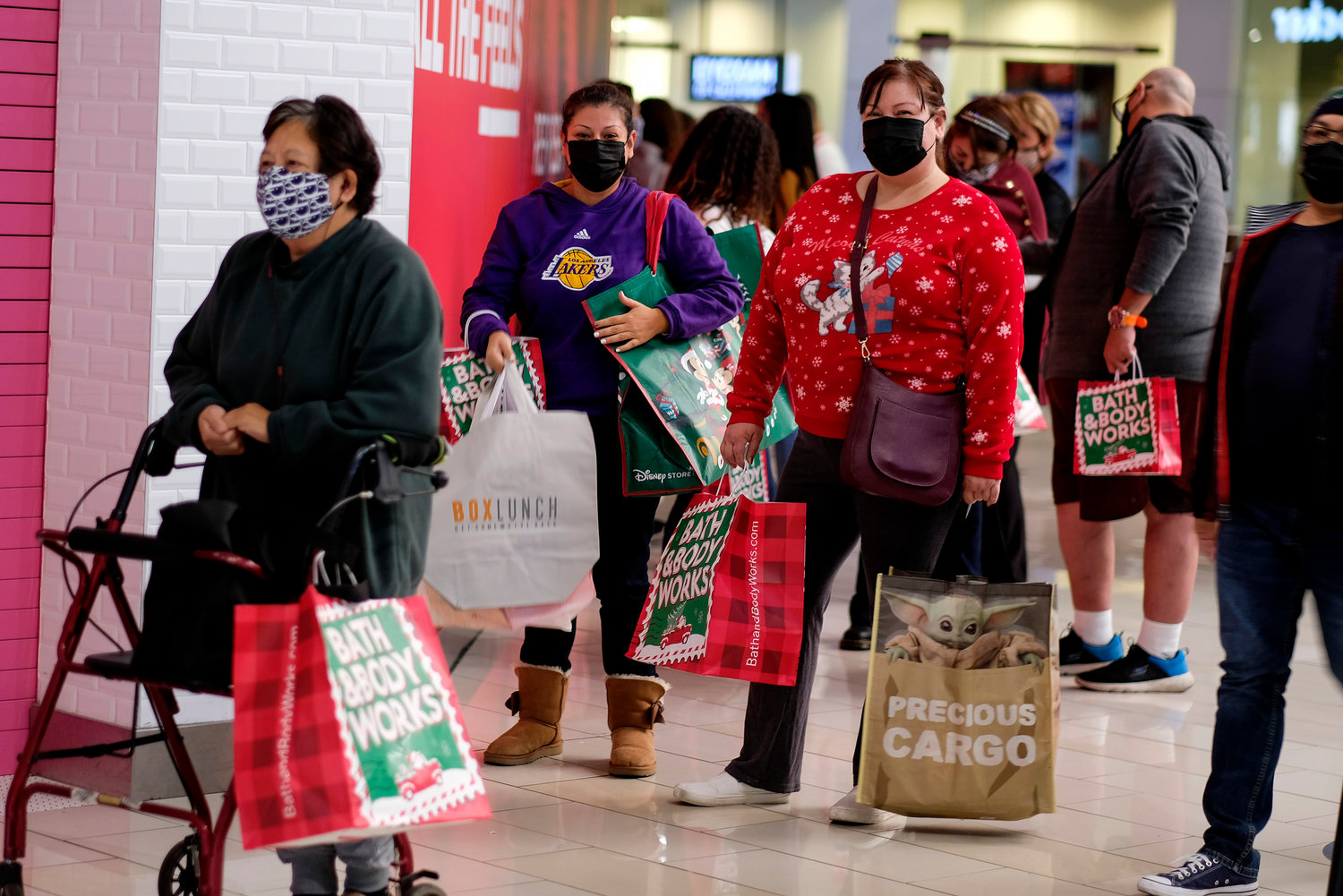 HOLIDAY SHOPPING BEGINS - Black Friday shoppers wearing face masks wait in line to enter a store at the Glendale Galleria in Glendale, Calif., Friday, Nov. 27, 2020. With online shopping continually on the rise, retailers and shippers are reminding shoppers of common scams to watch out for this year when placing orders.