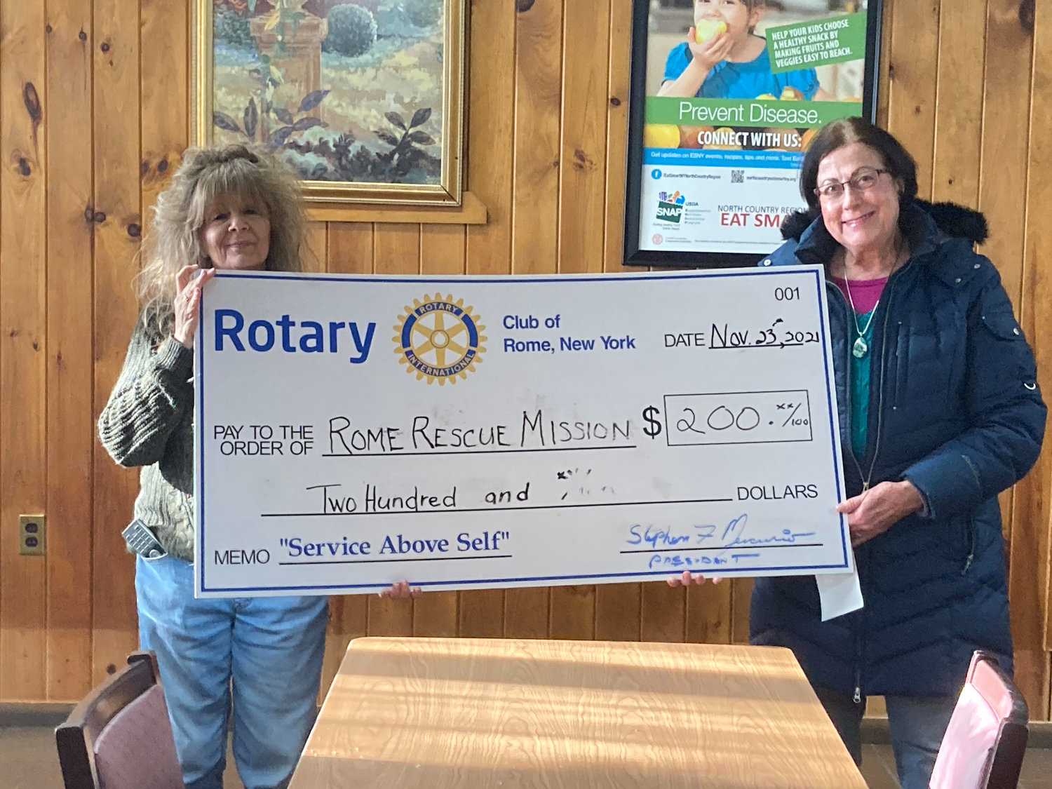 ROTARY SUPPORT — Rome Rotary’s Kris Dombeck, right, presents a cash donation to Lisa Patierno of the Rome Rescue Mission in support of the agency’s Annual Thanksgiving Meal Program. In addition to the cash donation, Rome’s Rotarians donated 27 turkeys and more than 150 pounds of other foods and deserts. During December, the Rome Rotary Club will be donating new Blankets for Veterans in Need. Kris-Tech Wire has donated of $250 toward the program. Rotary is asking the community to join the effort by dropping off new blankets at  1605 N. George St. Donations can also be sent to Rotary Club of Rome, Post Office Box 655, Rome, New York, 13442-065. (Photo submitted)