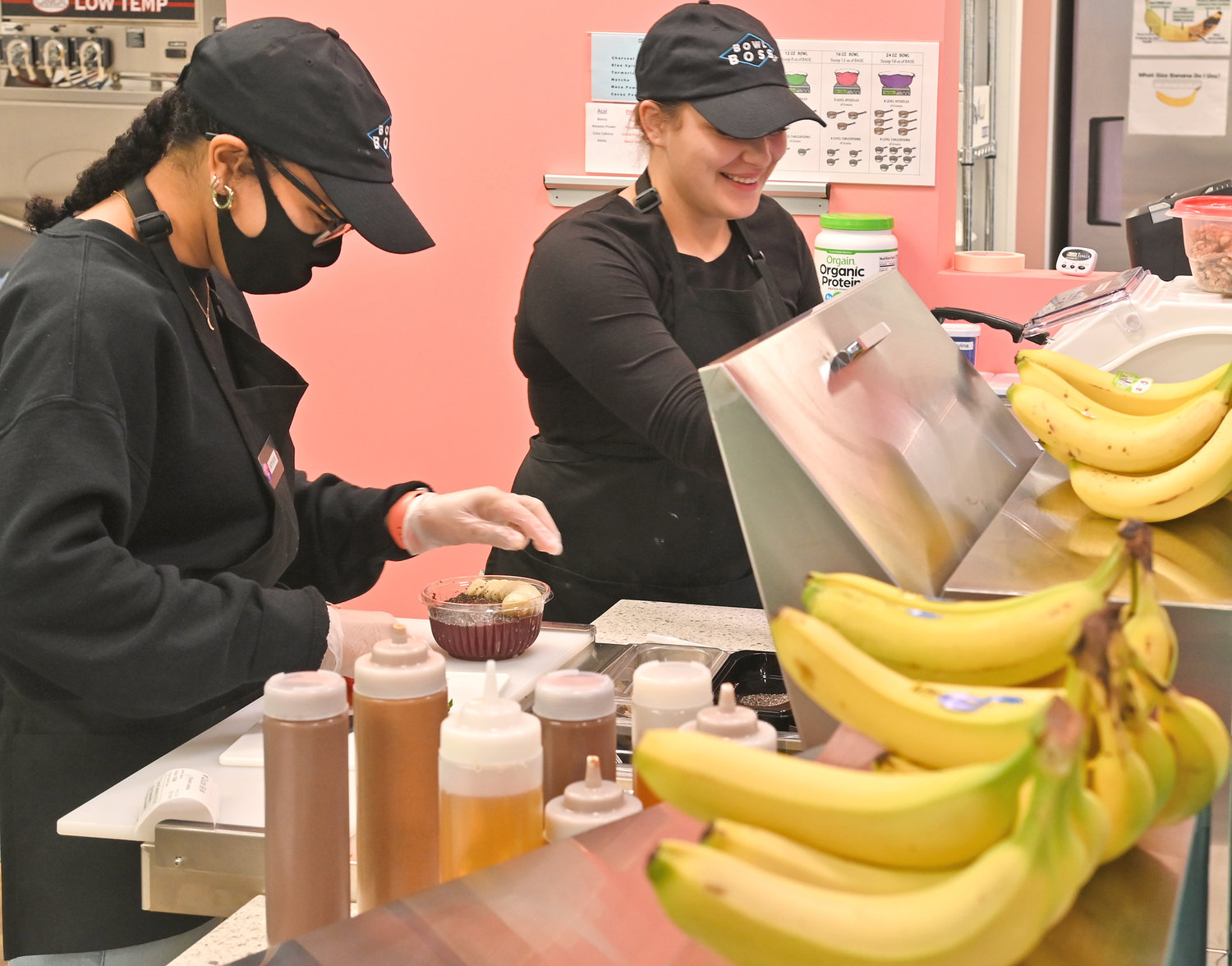BOWLISTA IN ACTION — Bowl Boss “Bowlistas” Ishmarai Hamid, left, and Alana Preski prepare a Coco Cabana bowl at the restuarant, located at 86 Hangar Road on the first floor of the Air City Lofts complex earlier this week. The business specializes in a variety of fruit bowls. For hours, and other information,visit its page on Facebook.