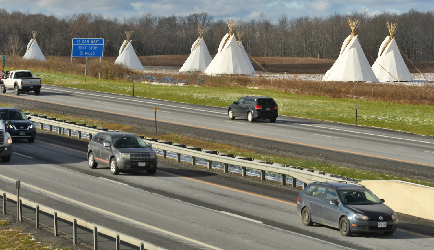 PASSAGE OF PEACE —  Comprising seven illuminated tipis located on Oneida Indian Nation lands just prior to Exit 33 of I-90, the Passage of Peace will run through the holidays. The Oneida Indian Nation chose the tipi as the Passage of Peace’s central image to recognize both these Western Tribal Nations and the collective challenges of Native American people. While the Oneidas and other Iroquois tribes lived in longhouses not tipis, the tipi is a universally recognized symbol of Native American identity. Lively east and westbound traffic on the NY State Thruway with the giant tipis on the north side of the through before the westbound Verona exit.