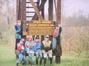 SIGNIFICANT SITE — A group of children pose near signage which gives both a brief history of the Utica Marsh as well as interesting facts about its significance to the local ecology. The DEC is seeking public input on a draft plan for the site.
