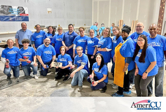 BUILDING BEDS FOR KIDS IN NEED — AmeriCU employees and volunteers pose after their efforts in October, assembling beds for dozens of children in need in the Utica area. As part of the sponsorship, the credit union also supplies the mattresses needed for the beds made.