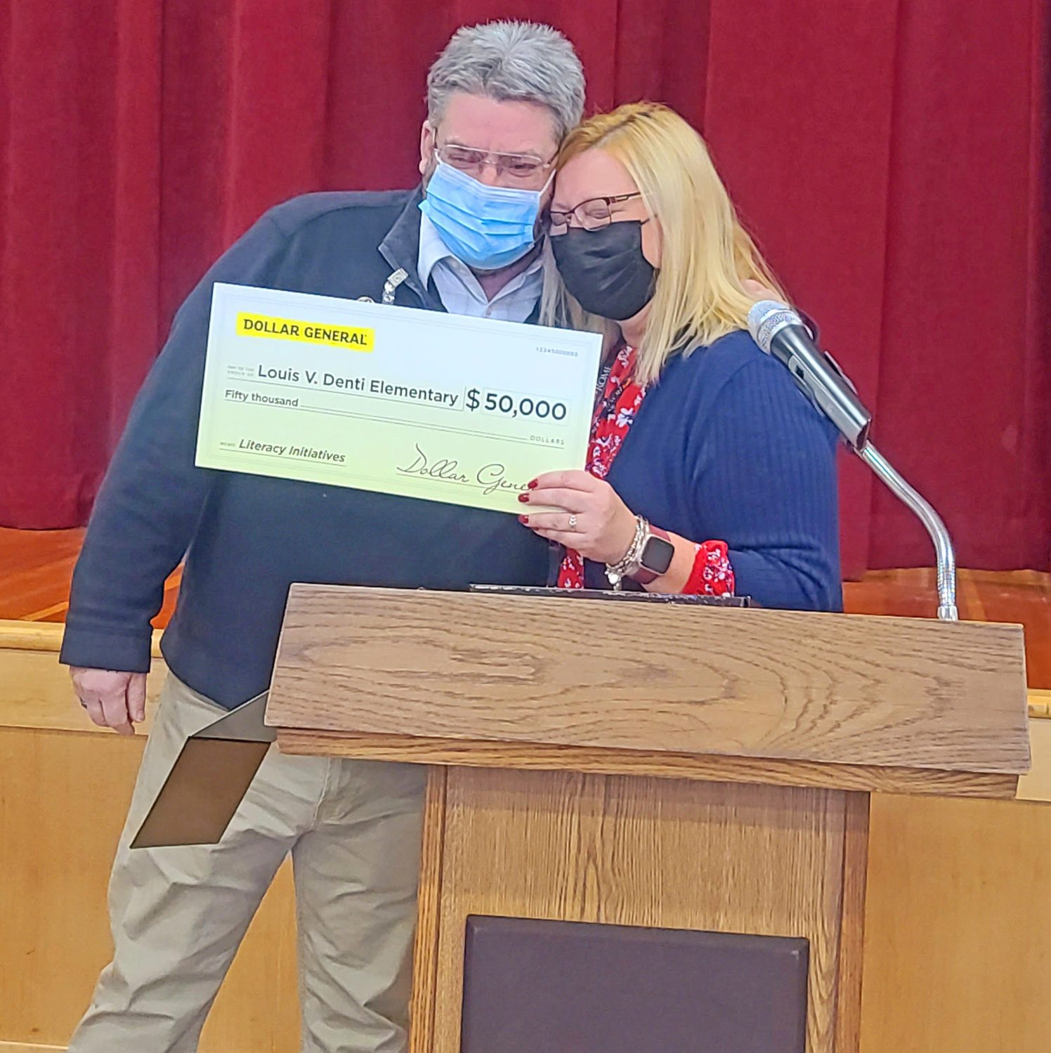 CHECK PRESENTATION — Dollar General Regional Director Matt Abernathy presents Dentil Principal Sherry Lubey with a $50,000 check to promote literacy.