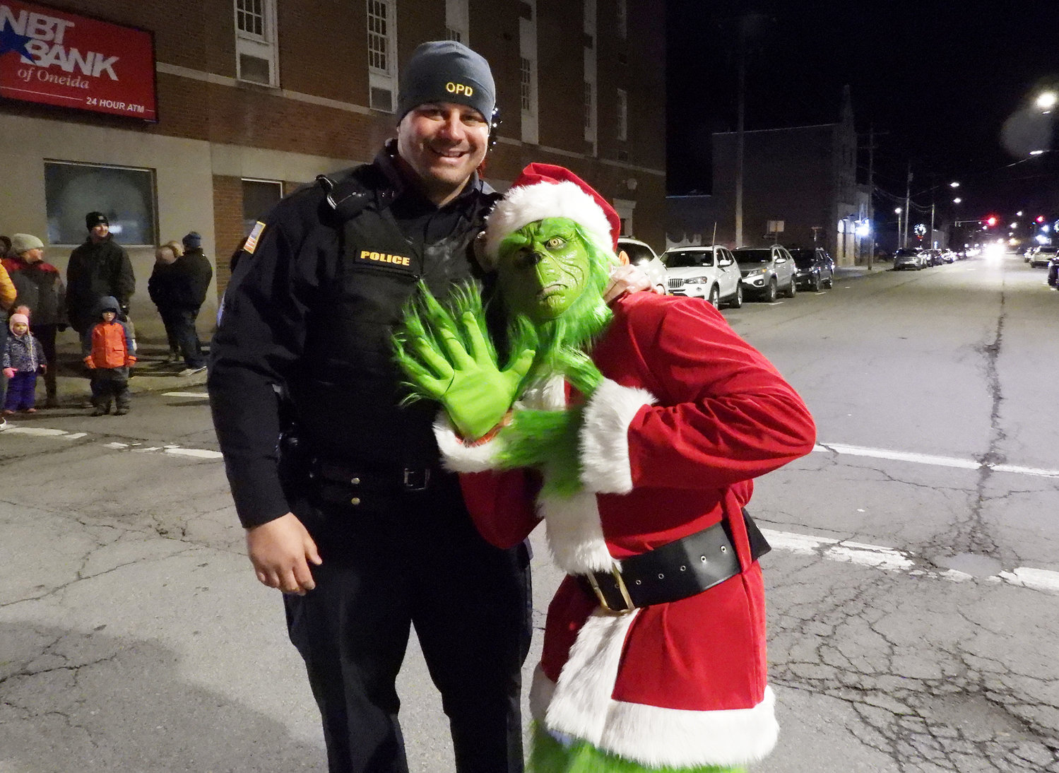 MAKING FRIENDS WITH THE GRINCH — Sergeant David Meeker Jr. finds the Grinch walk the streets of Oneida before the inaugural Parade of Lights. For more photos of the Oneida Christmas Festival, visit the Rome Sentinel website.