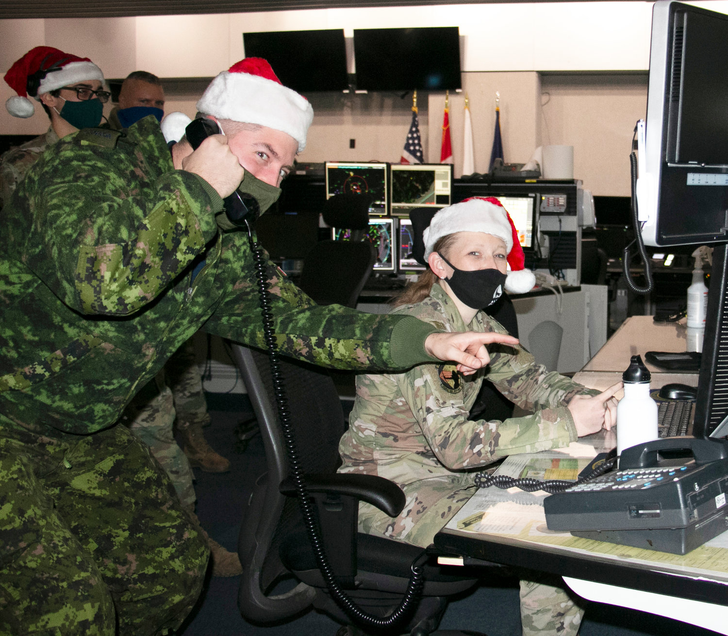 READY FOR GO TIME — Capt. Kevin Vincent, left, of the Royal Canadian Air Force, and  Airman 1st Class Megan Mills, of the New York Air National Guard‚ 224th Air Defense Squadron, conduct training recently at the Eastern Air Defense Sector in Rome in preparation for NORAD Tracks Santa operations on Christmas Eve. The EADS staff stands ready, its commander says, to assist Santa on his ‘critical mission.’