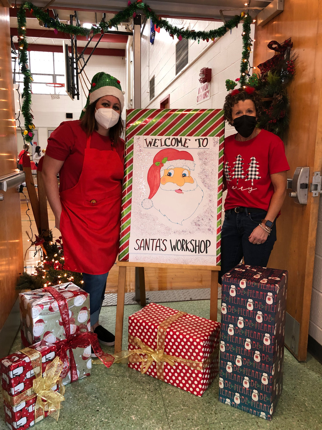 SANTA’S HELPERS — J.D. George Elementary School faculty members Rachel Pace, left, and Eileen Bleaking, right, the event coordinator, put the finishing touches on Santa’s Workshop, an event geared to help students enjoy the gift of giving during the holiday season.