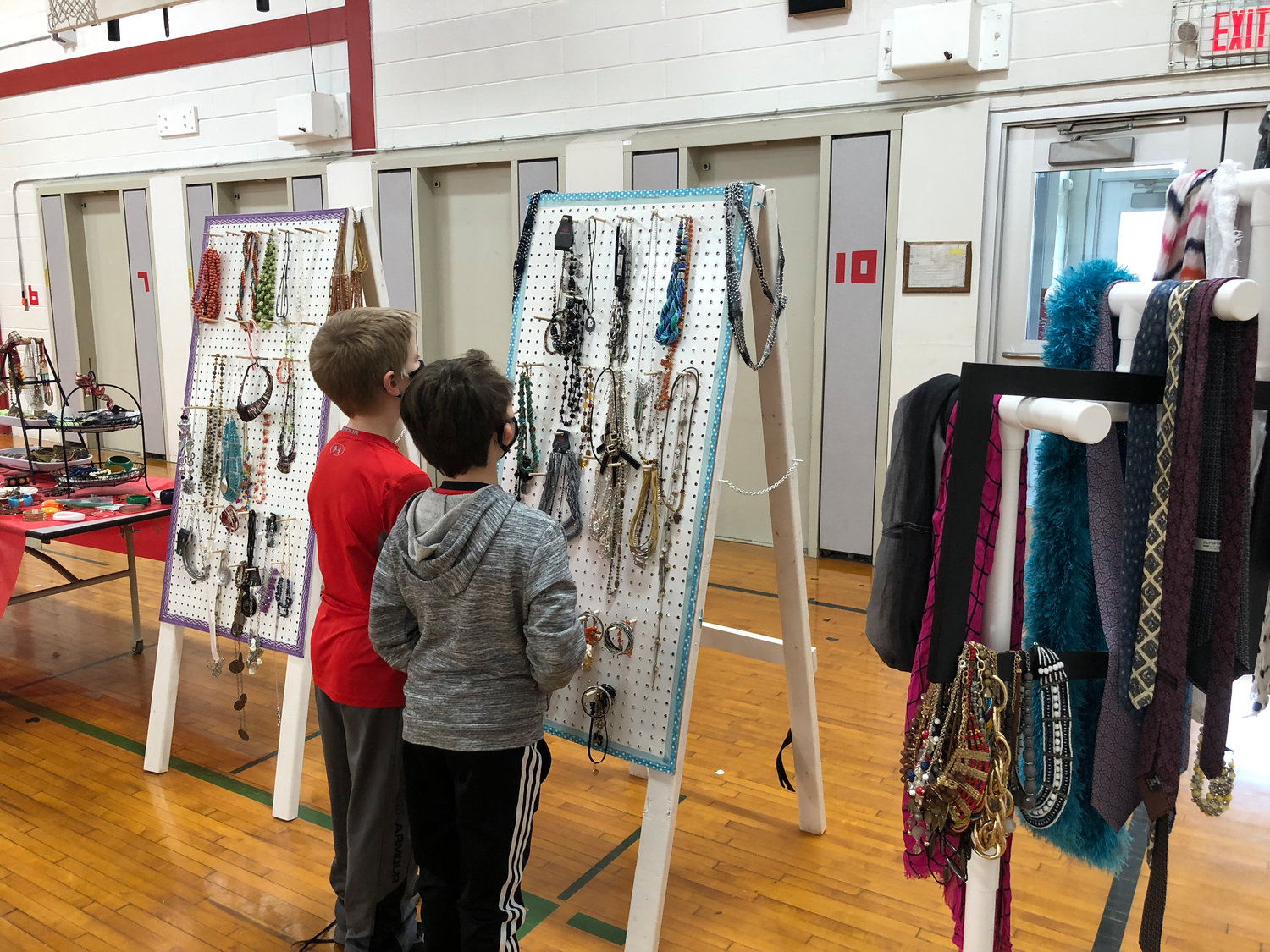 HMMMM...WHICH IS THE PERFECT ONE... — A pair of students look over a selection of jewelry at Santa’s Workshop at the J.D. George Elementary School recently.