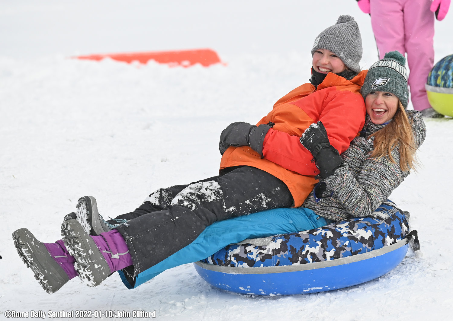 Kelly Reese and Elena Roberts slide down the Ridgewood Heights Park hill in Rome Monday afternoon.