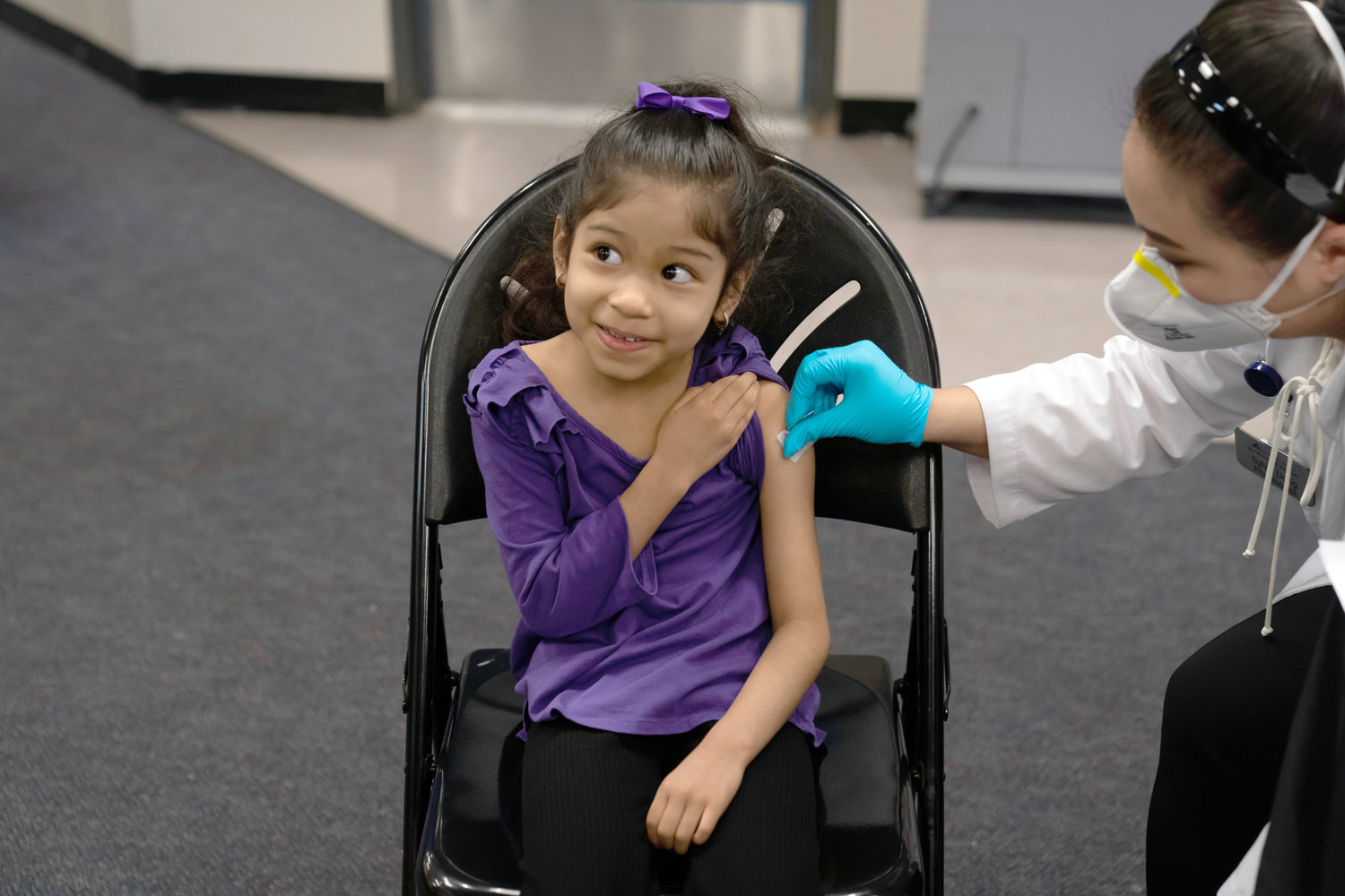 FIRST SHOT — Elsa Estrada, 6, smiles at her mother as pharmacist Sylvia Uong applies an alcohol swab to her arm before administering the Pfizer COVID-19 vaccine at a pediatric vaccine clinic for children ages 5 to 11 set up at Willard Intermediate School in Santa Ana, Calif.