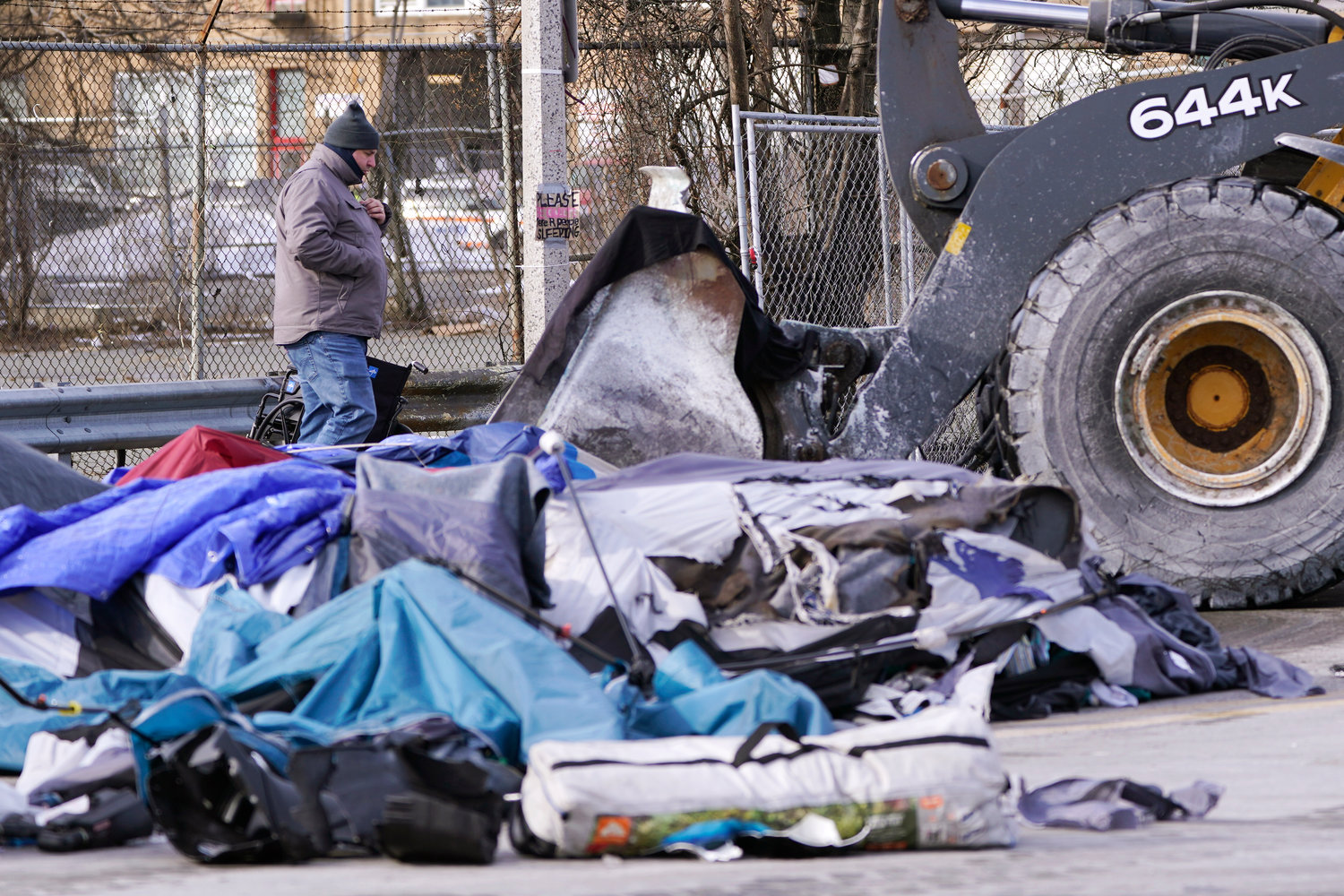 CLEANING UP — A City of Boston worker watches as a front-end loader scoops up tents, furniture and other items as a homeless encampment is cleared from the street Wednesdayin Boston. Boston Mayor Michelle Wu's made good on a self-imposed deadline to move people living in a homeless camp off the streets and into housing.