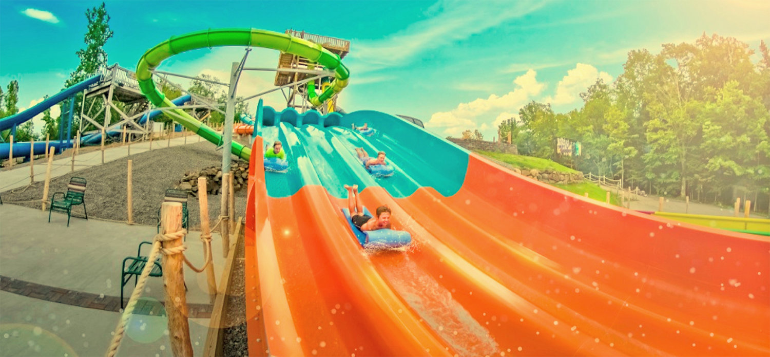 NEVER TOO SOON — Sliders splish and splash their way down the four-lane, 300-foot mat slide at the Water Safari Resort in Old Forge in this illustration. The North Country attraction has joined the National Plan for Vacation effort to help residents plan – and not lose — their earned vacation time.