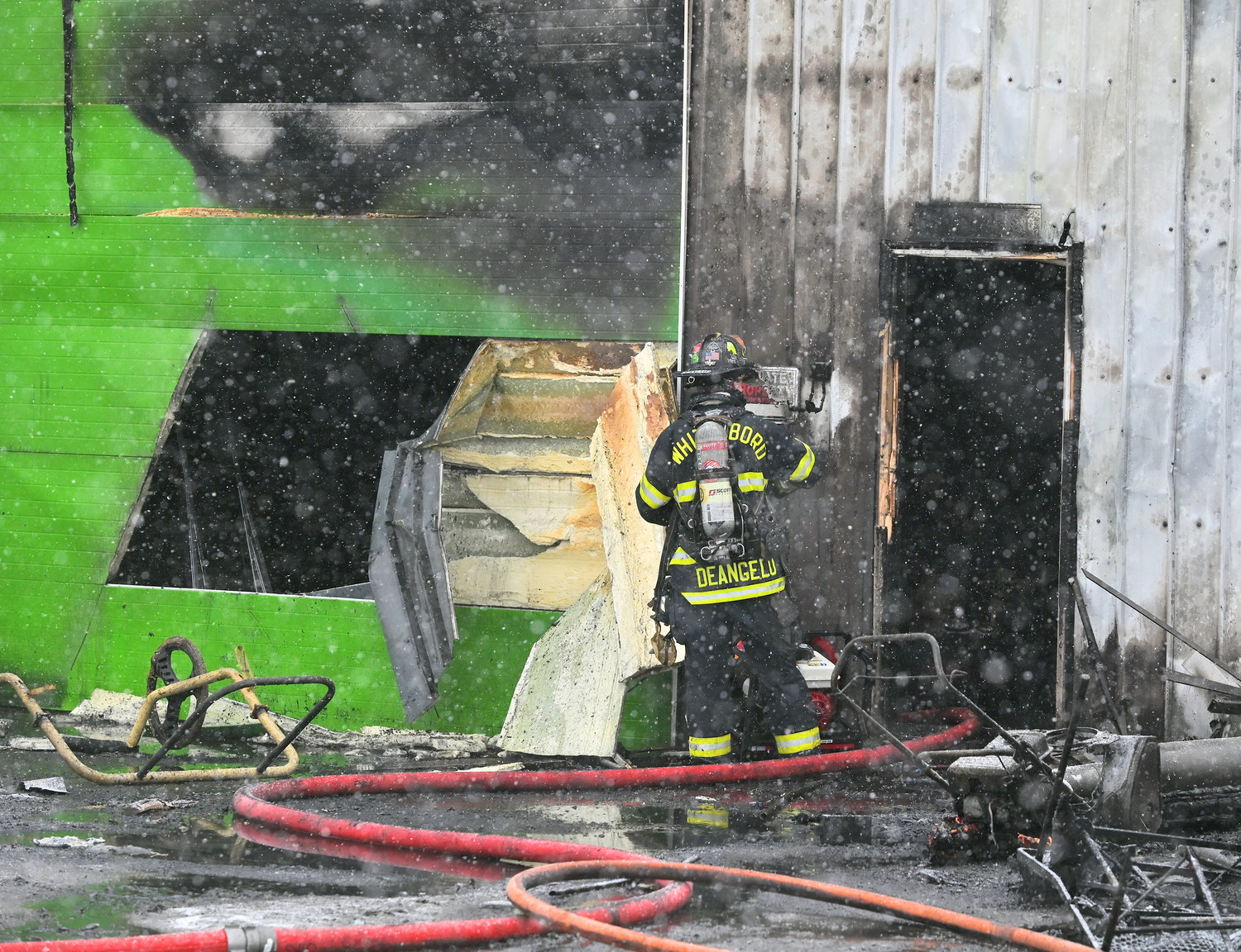 BUSINESS BURNED — A volunteer firefighter from Whitesboro checks the walls at Nick's Lawn Service on Main Street after the building was heavily damaged by a fire Tuesday afternoon.