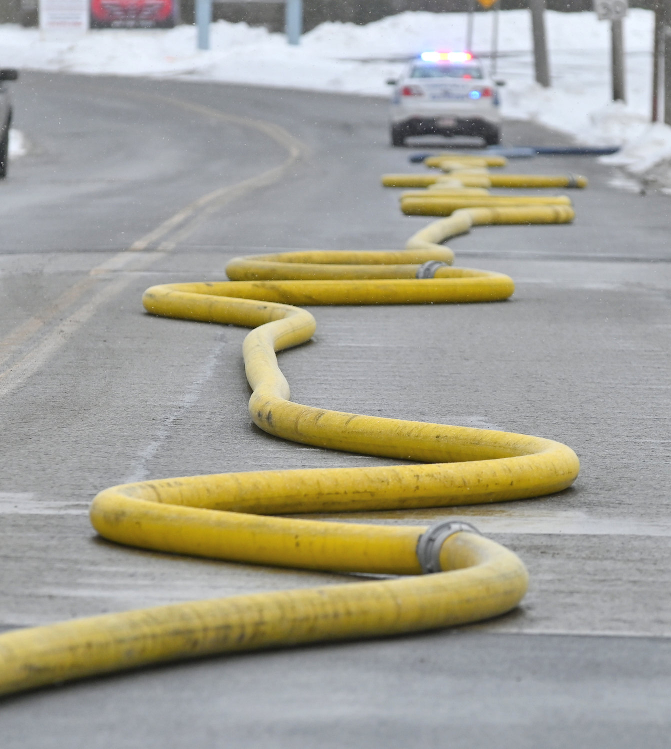 WORK TO BE DONE — A thick hoseline snakes down Main Street in Whitesboro, delivering much-needed water from a hydrant to the firefight at Nick's Lawn Service.