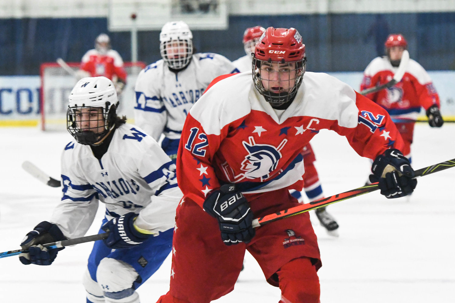MAKING A PLAY — New Hartford player Will Gall (12) races toward the puck during the game against Whitesboro on Tuesday at Whitestown Ice Rink. He had a goal and two assists in New Hartford’s win. The Spartans won 5-2.