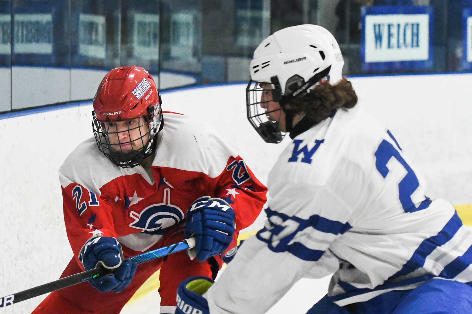From left, New Hartford player Gabriel Syrotynski moves the puck against Whitesboro player John Welch during the game on Tuesday, Feb. 8.