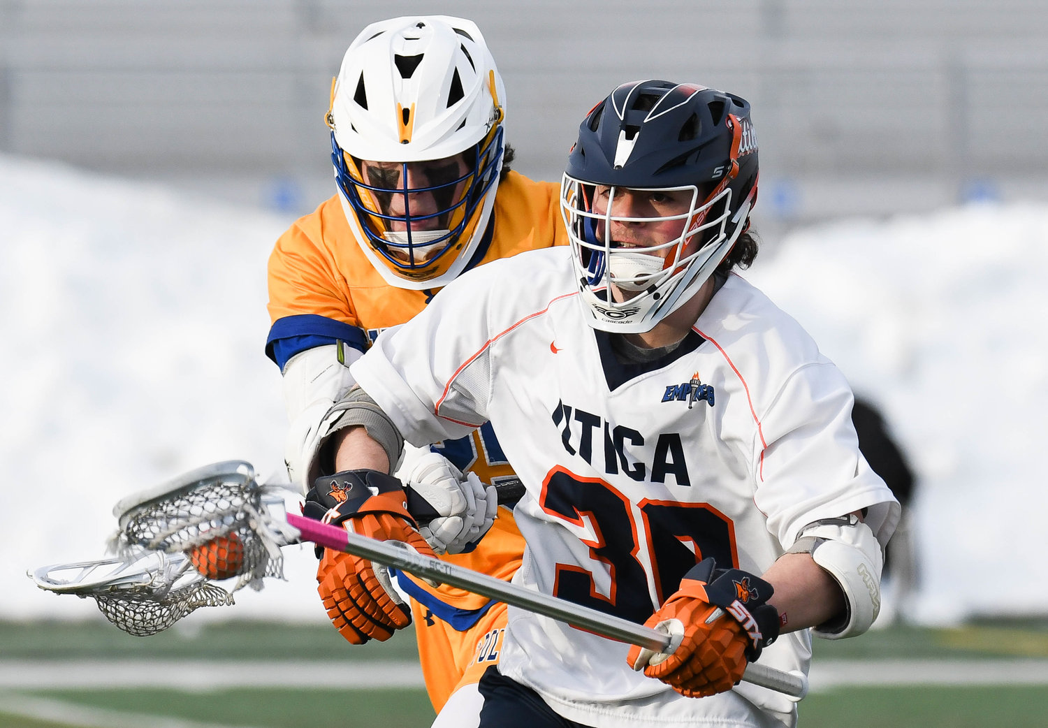 BATTLE — SUNY Poly's Shane Wyman defends Utica University's Andrew Sacco during the men's lacrosse game on Wednesday at Gaetano Stadium. The Pioneers downed the Wildcats 8-4 in the 2022 season opener for Utica.