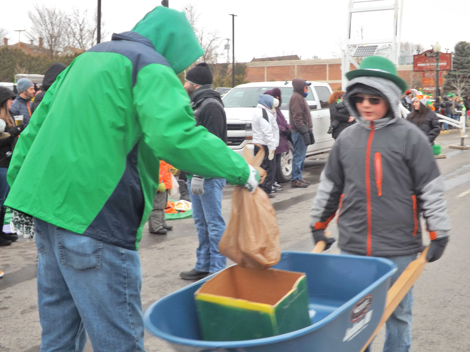 HELP FOR HUNGRY — An attendee of a previous St. Patrick’s Day Parade in Utica donates non-perishable food items in this file photo. Event organizers are once again collection donations of food or money to help the Mother Marianne West Side Kitchen feed those in need in the community.