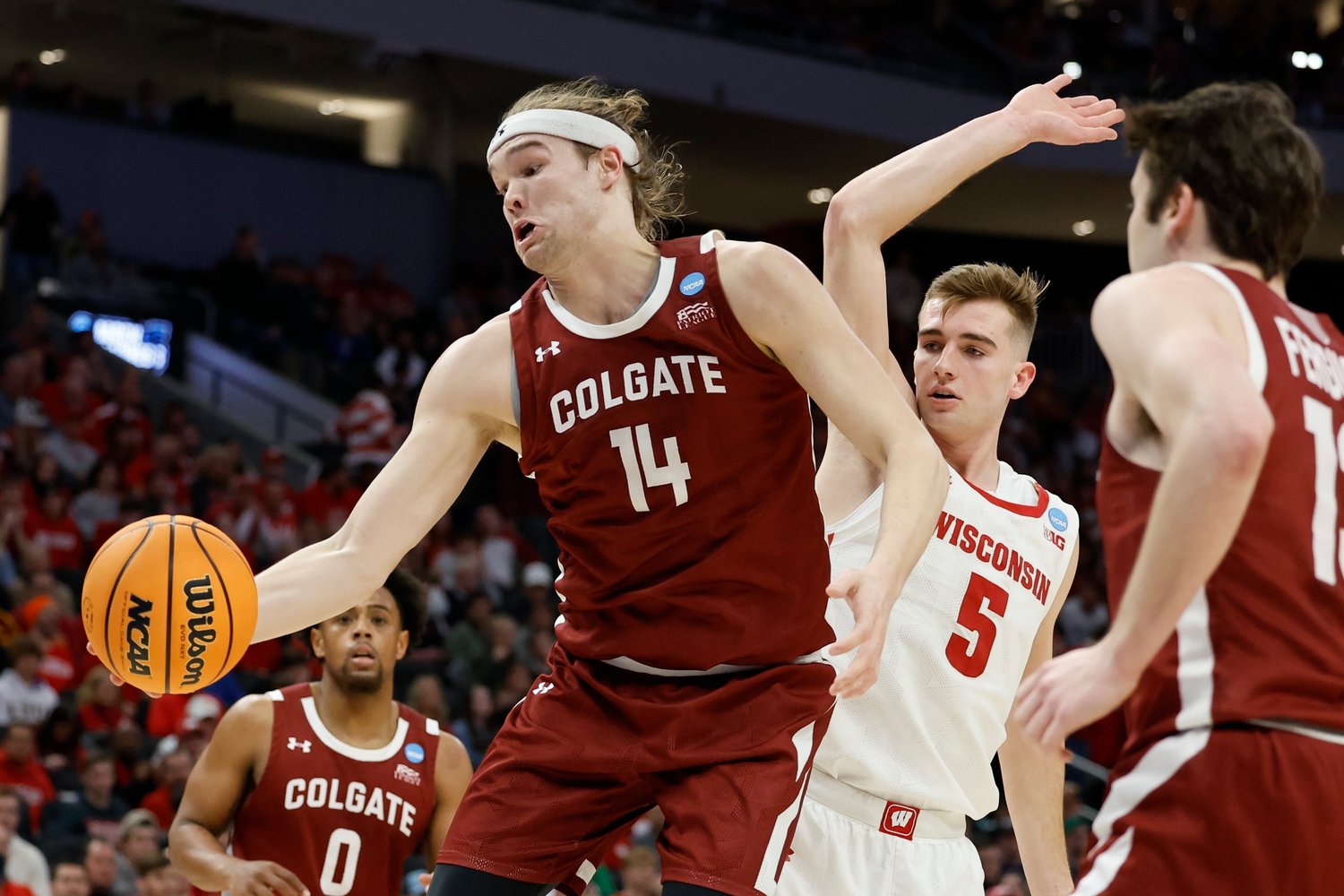 HUSTLE PLAY — Colgate's Keegan Records grabs a loose ball in front of Wisconsin's Tyler Wahl during during the first half of a first-round NCAA men's basketball tournament game on Friday night in Milwaukee.