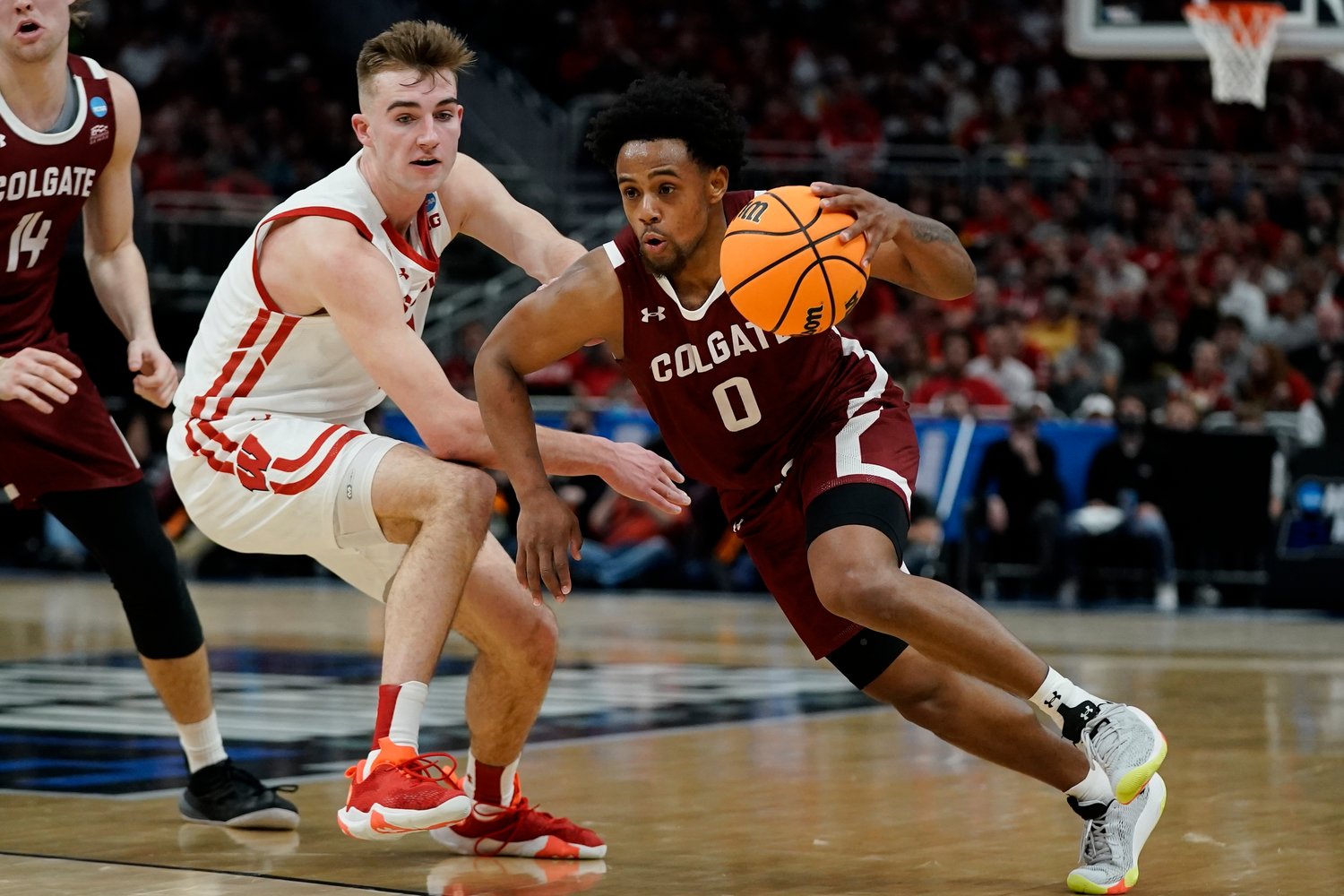 DRIVING BY — Colgate's Nelly Cummings drives by Wisconsin's Tyler Wahl during the first half of a first-round NCAA men's basketball tournament game on Friday night in Milwaukee.