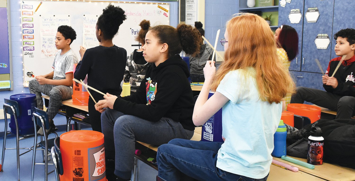 Students in Stephanie Mahoney's music class at Bellamy make unique sounds on the bucket drum.