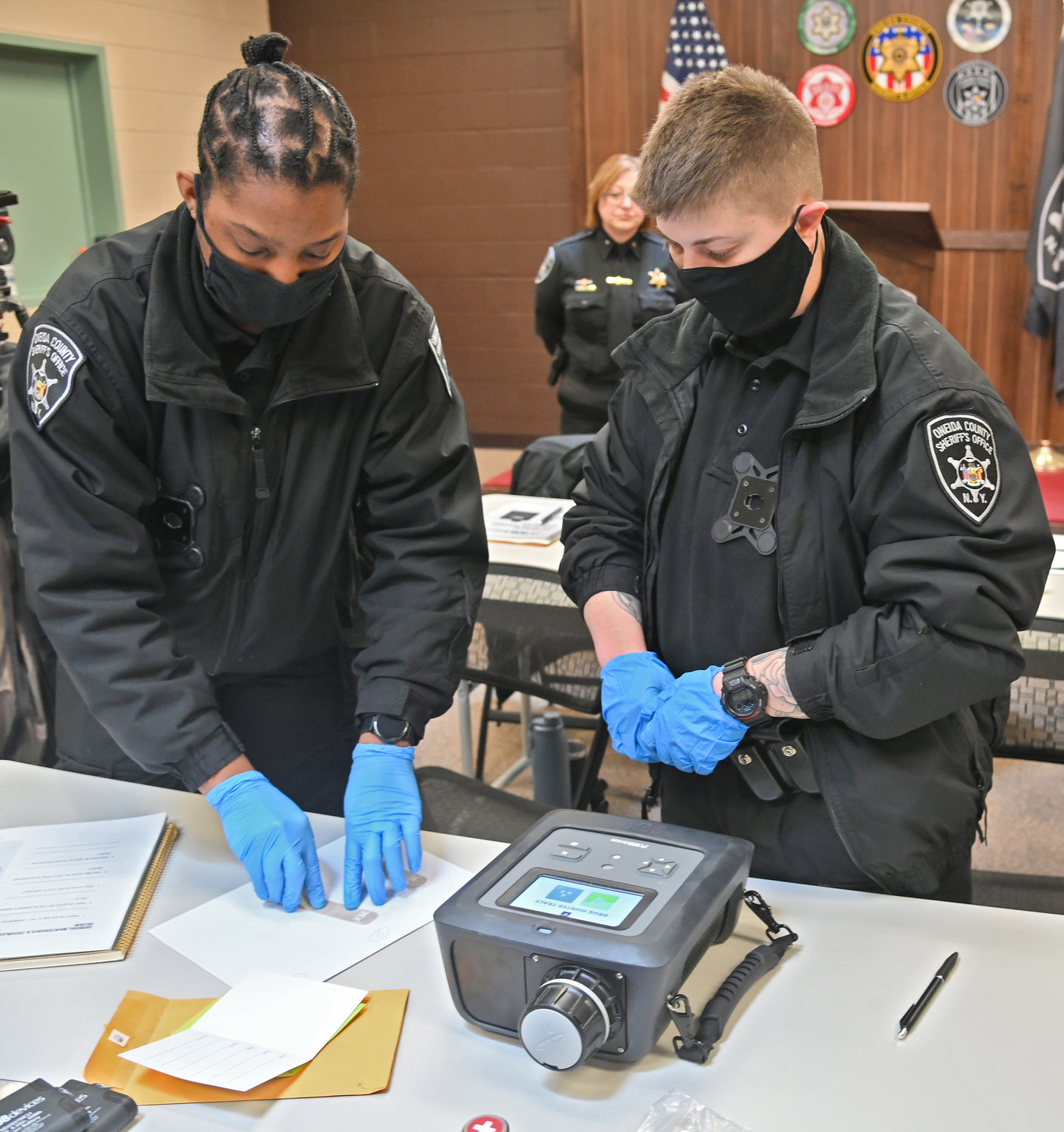 HANDS ON TESTING — Corrections Officer Leslie and Officer DiFederico demonstrate the new MX908 drug detection device purchased for the Oneida County Jail.