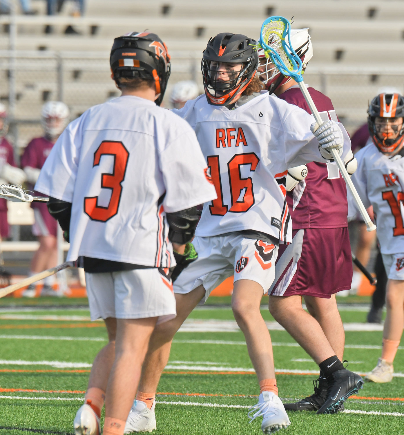 FIRST QUARTER GOAL — RFA's Logan Waterman, center, celebrates his first quarter goal with teammate Max Hunt in Tuesday's season opener at RFA Stadium. The Black Knights lost 12-10.