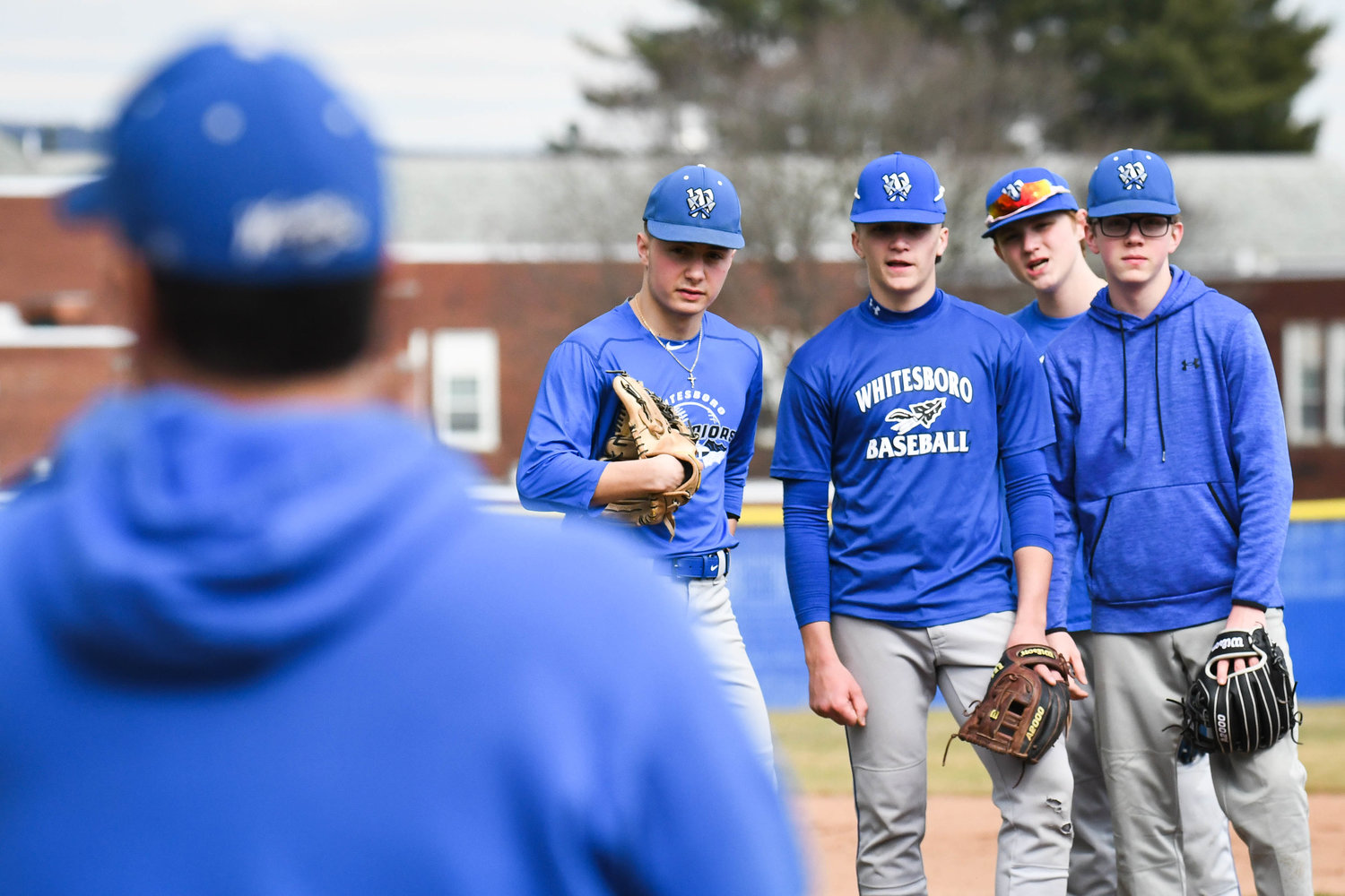 TALK IT OUT — Whitesboro players listen to head coach Tom Maggiolino from the mound during practice on Tuesday.