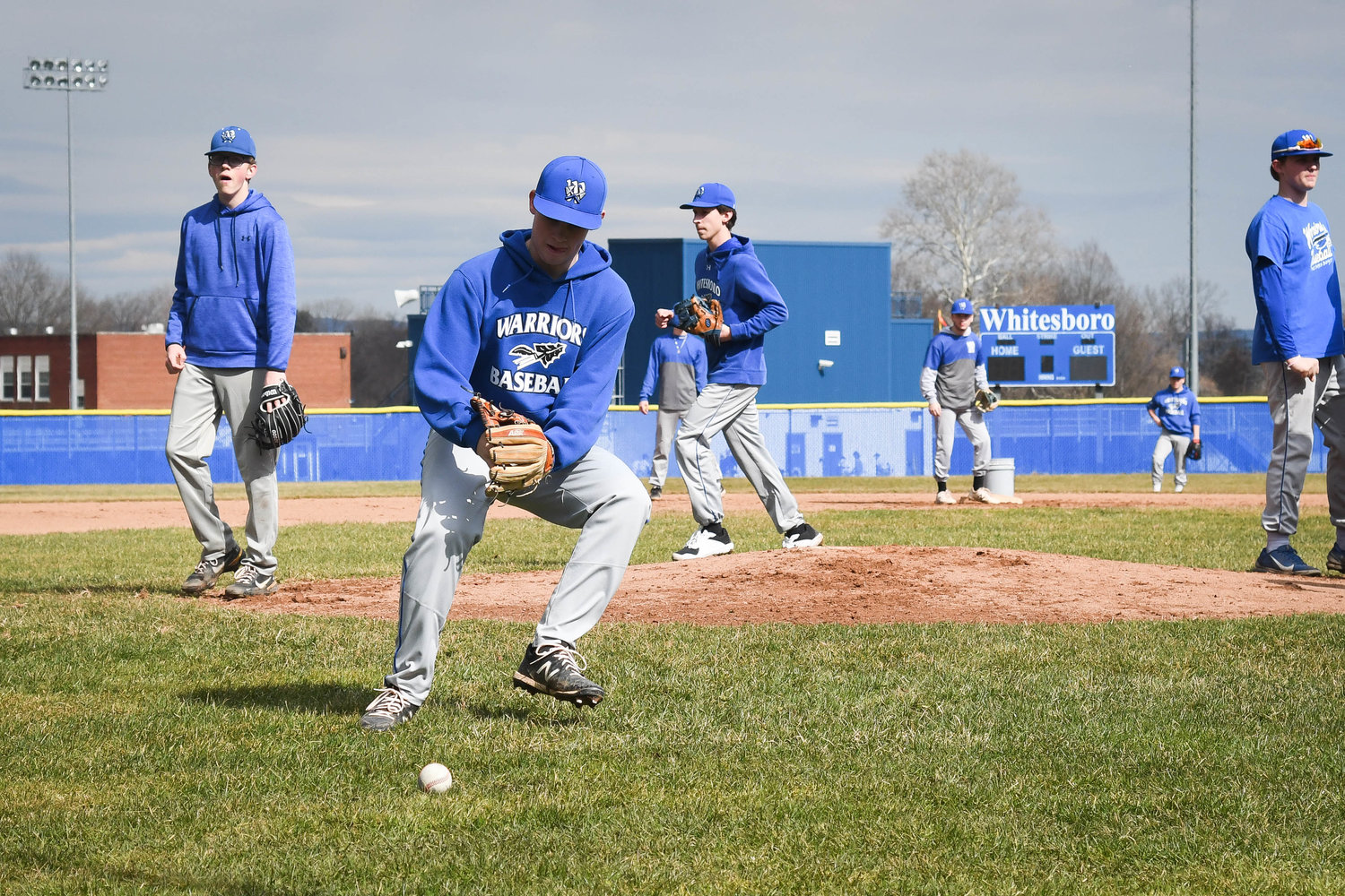 EYE ON THE BALL — Whitesboro players run pitcher fielding drills during practice on Tuesday. Whitesboro is coming off a 13-3 season and pitching is expected to be one key for the Warriors this season.
