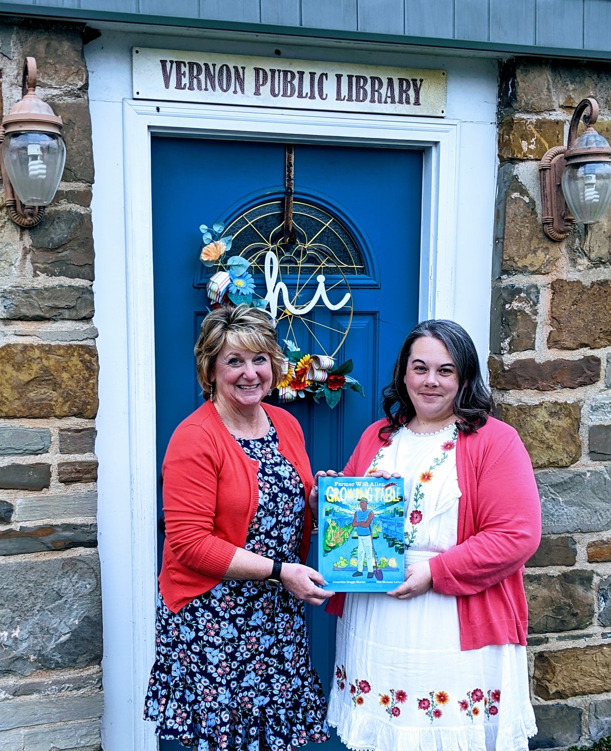 CHECK OUT AGRICULTURE — Oneida County Farm Bureau Promotion and Education Chair Karen K. Howard, left, presents Robyn Coufal, right, director of the Vernon Public Library with this year’s Agriculture Literacy Book choice, “Will Allen and the Growing Table.”