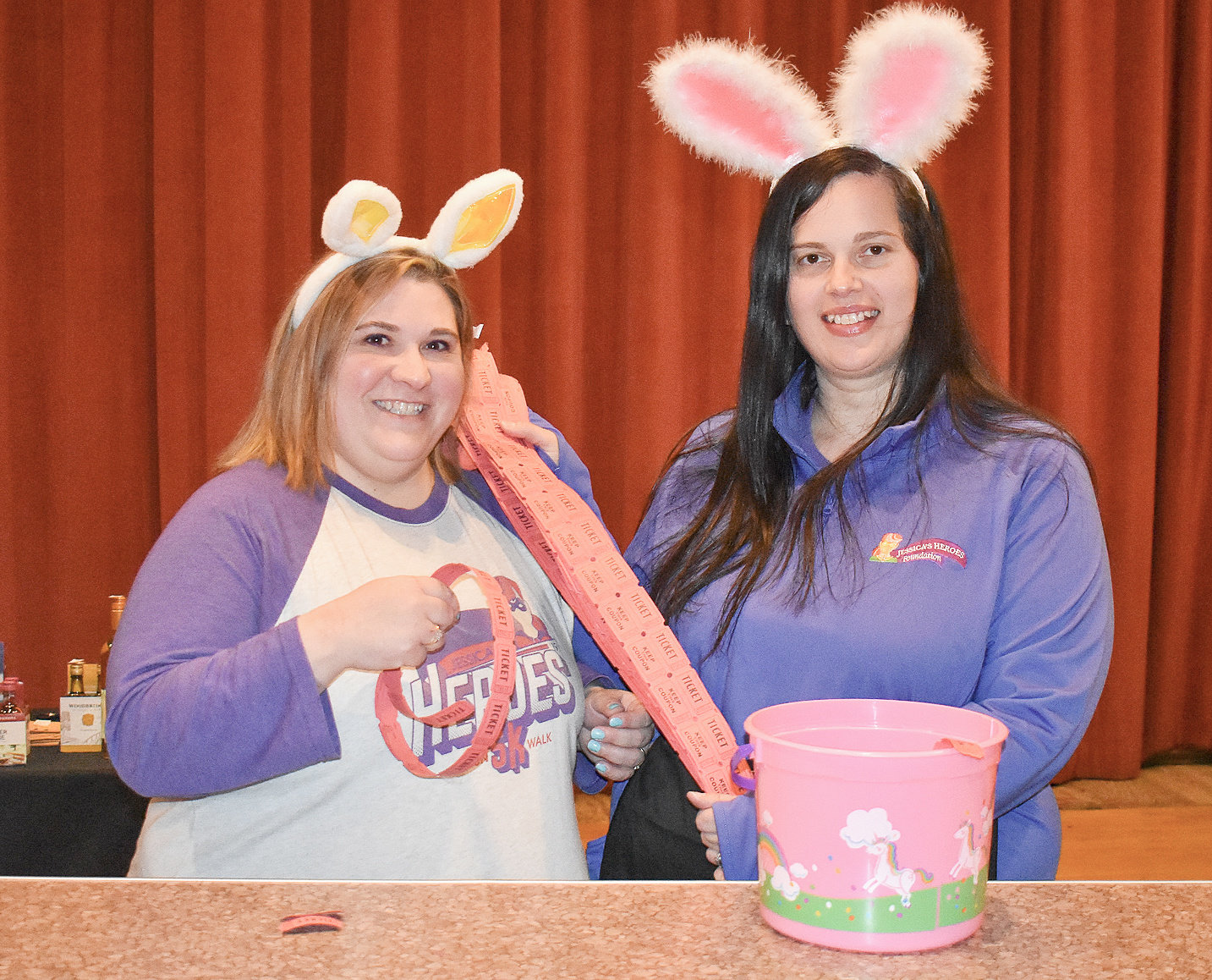 RAFFLE BASKETS — A 50/50 raffle was held at Jessica's Heroes Adult Easter Egg Hunt on April 9. Pictured are Jessica's Heroes Committee Members Brandy DuChene, left, and Shearen Grinnell holding a number of tickets being sold to attendees.