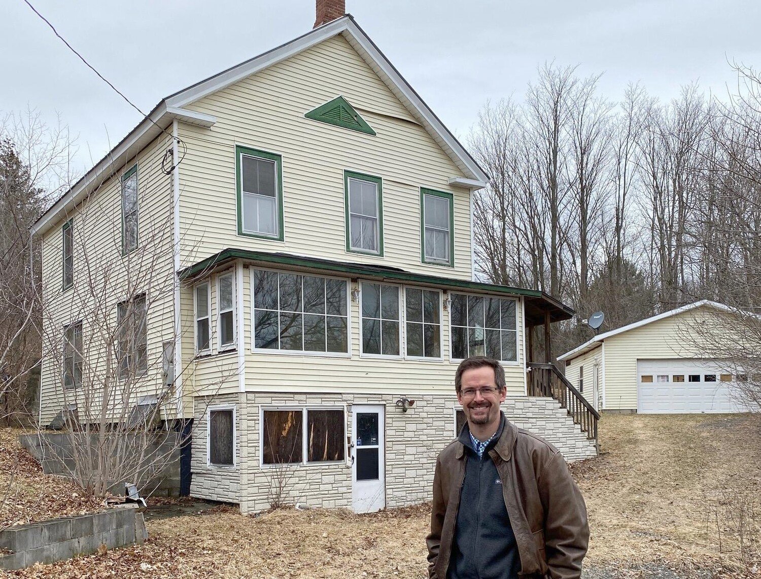 LAND BANK — Essex Town Supervisor Ken Hughes stands in front of a home he was to rehabilitate using a land bank model.