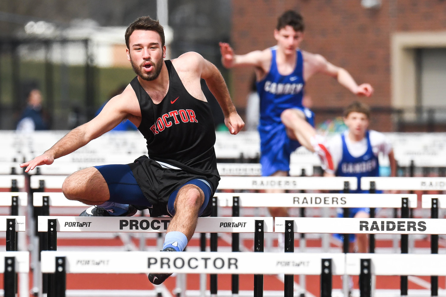 RELAY RACERS — Thomas R. Proctor High School runner Devin Muniz competes in the 110-meter hurdle event during a track and field relay meet on Tuesday at PHS Stadium in Utica. The two Proctor hurdlers won the relay and the Raiders won the overall event.