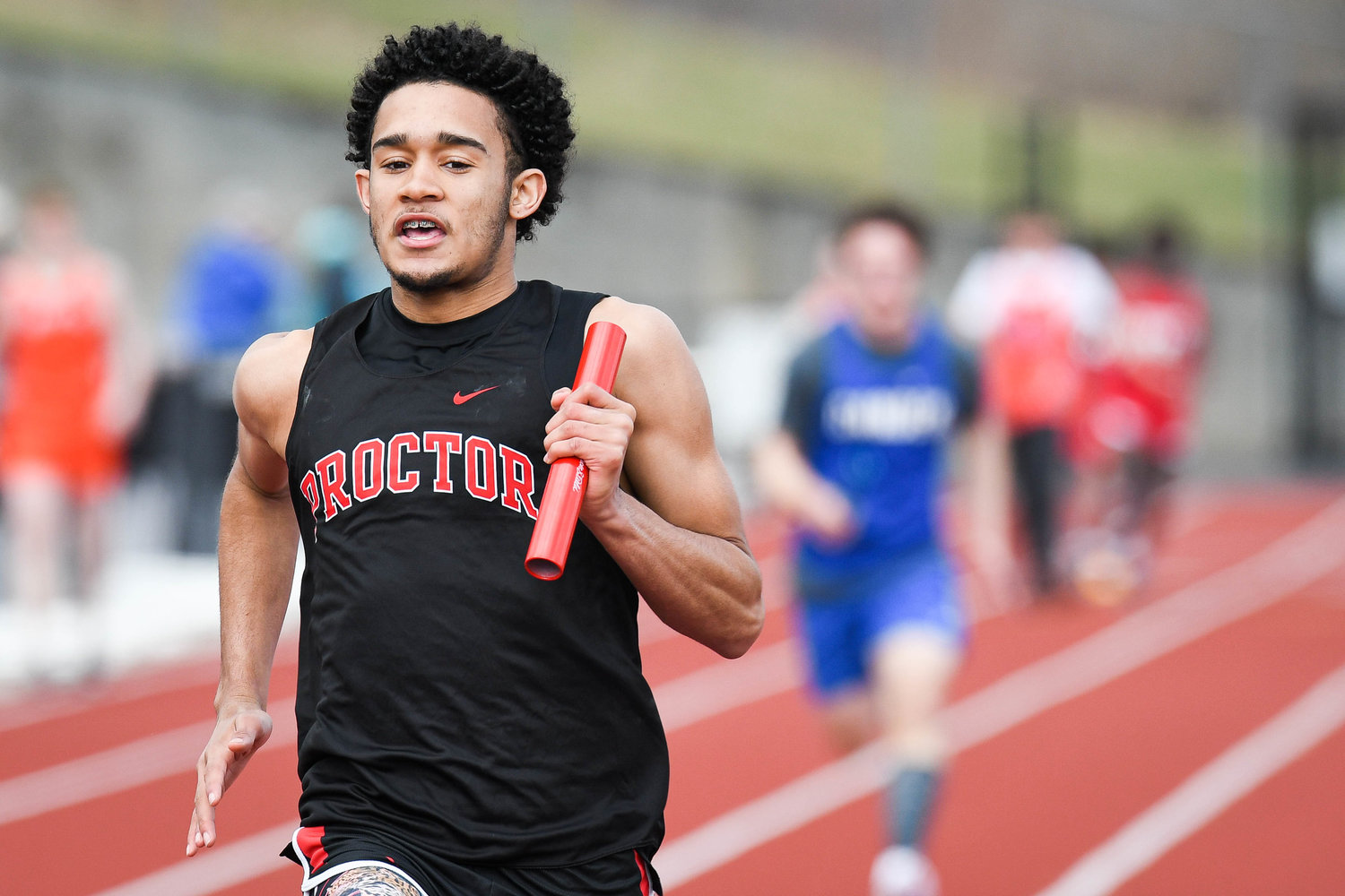 Thomas R. Proctor runner Chris Mateo competes in a 4 by 100 meter relay event during a track and field meet on Tuesday at PHS Stadium in Utica.