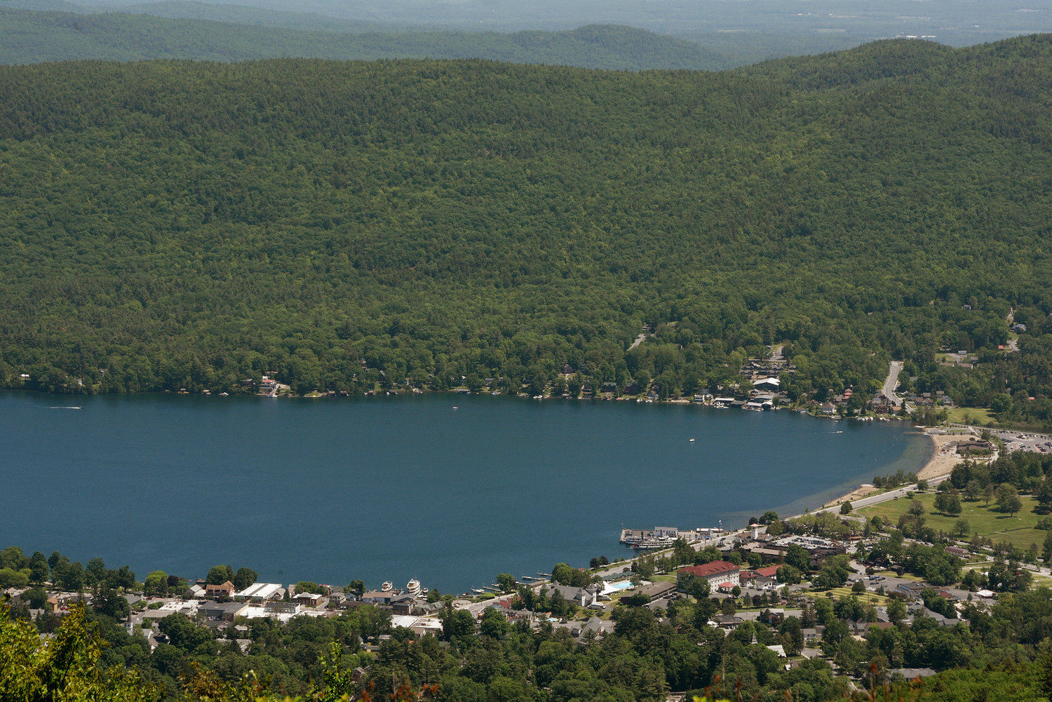 DEALING WITH INVASIVES — Views of Lake George Village from Prospect Mountain from the outlook view stops, in Lake George are shown in this June 2019 file photo. Officials and residents are grappling with a plan to kill invasive milfoil, a highly invasive aquatic plant that often kills off native plants, with herbicide in two Lake George bays.