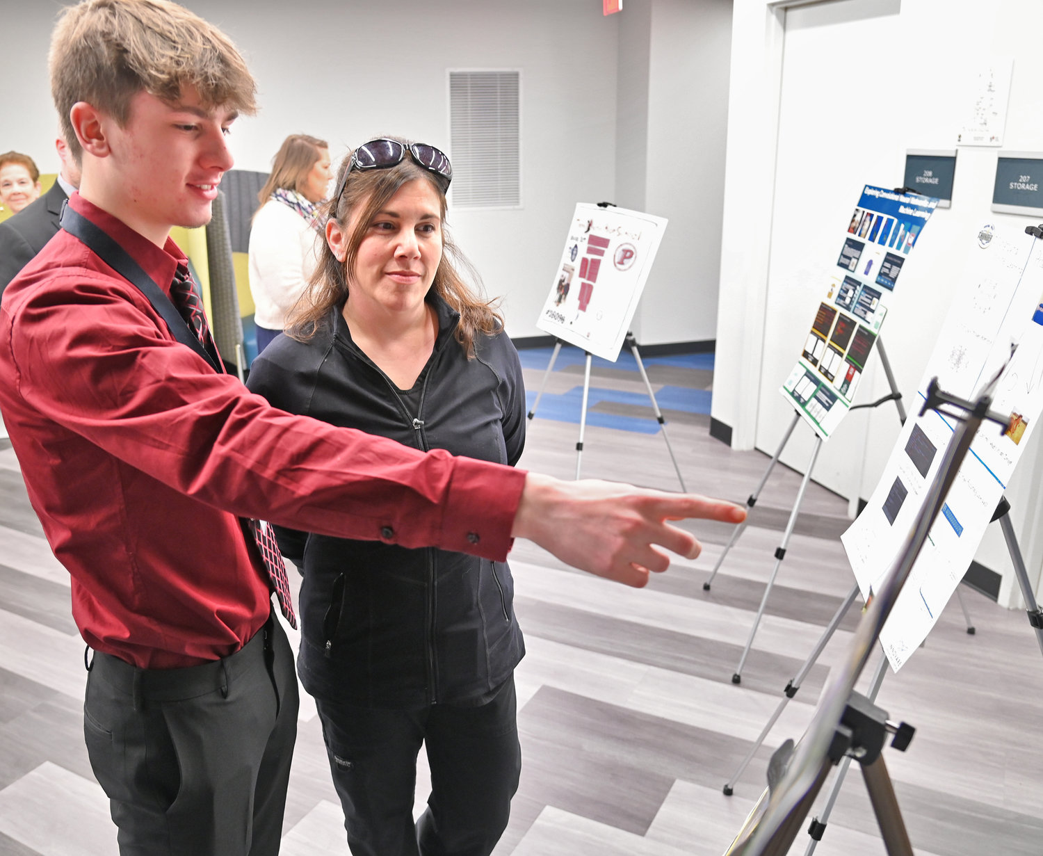 Kaleb Lanz a junior at Onedia HS shows his mom LeAnn his poster before the start of the awards ceremony at Innovare Friday afternoon. His project focused on drones differentiating between humans and animals in the event of a natural disaster.