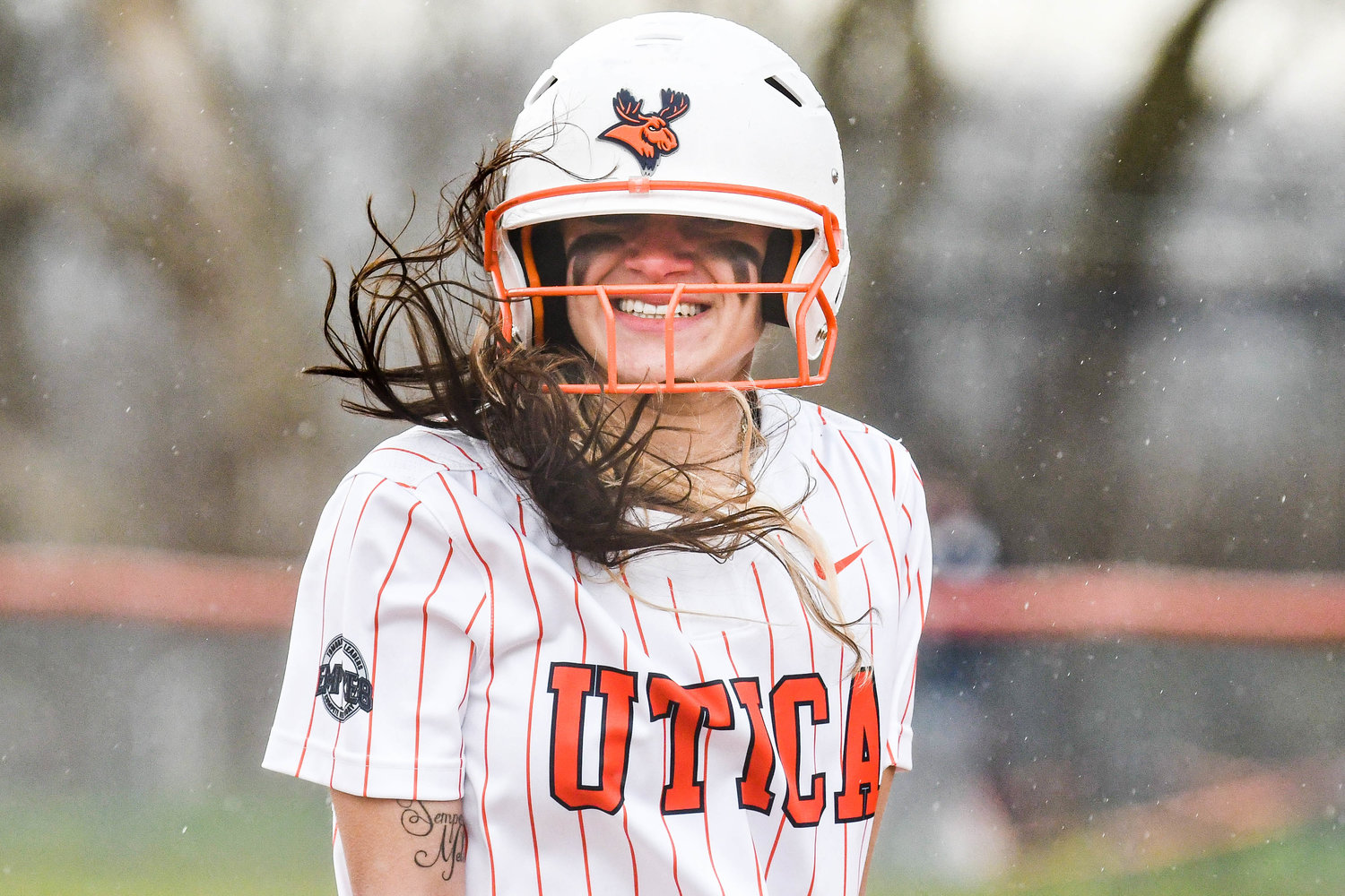 WINDY DAY — Utica University player Abriana Wadley smiles while standing in strong winds and rain during game two of a doubleheader against Russell Sage. The Pioneers split the twin bill, losing 2-1 in game one and winning 12-7 in game two.