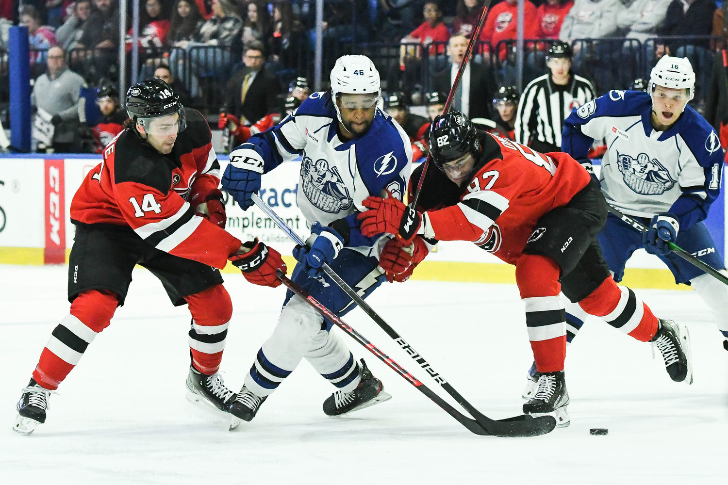 CRUNCH -- Comets players Tyler Irvine and Nikita Okhotiuk defend against Syracuse Crunch player Gemel Smith during the game on Friday night. Okhotiuk had a goal and fight in the 5-1 win.