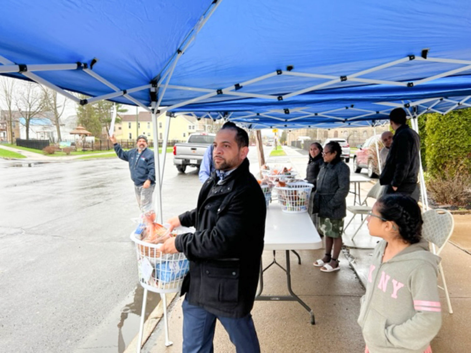 Baskets of food are moved by volunteers and church-goers at the food giveaway organized by four of the Seventh-Day Adventist Churches in the city of Utica.