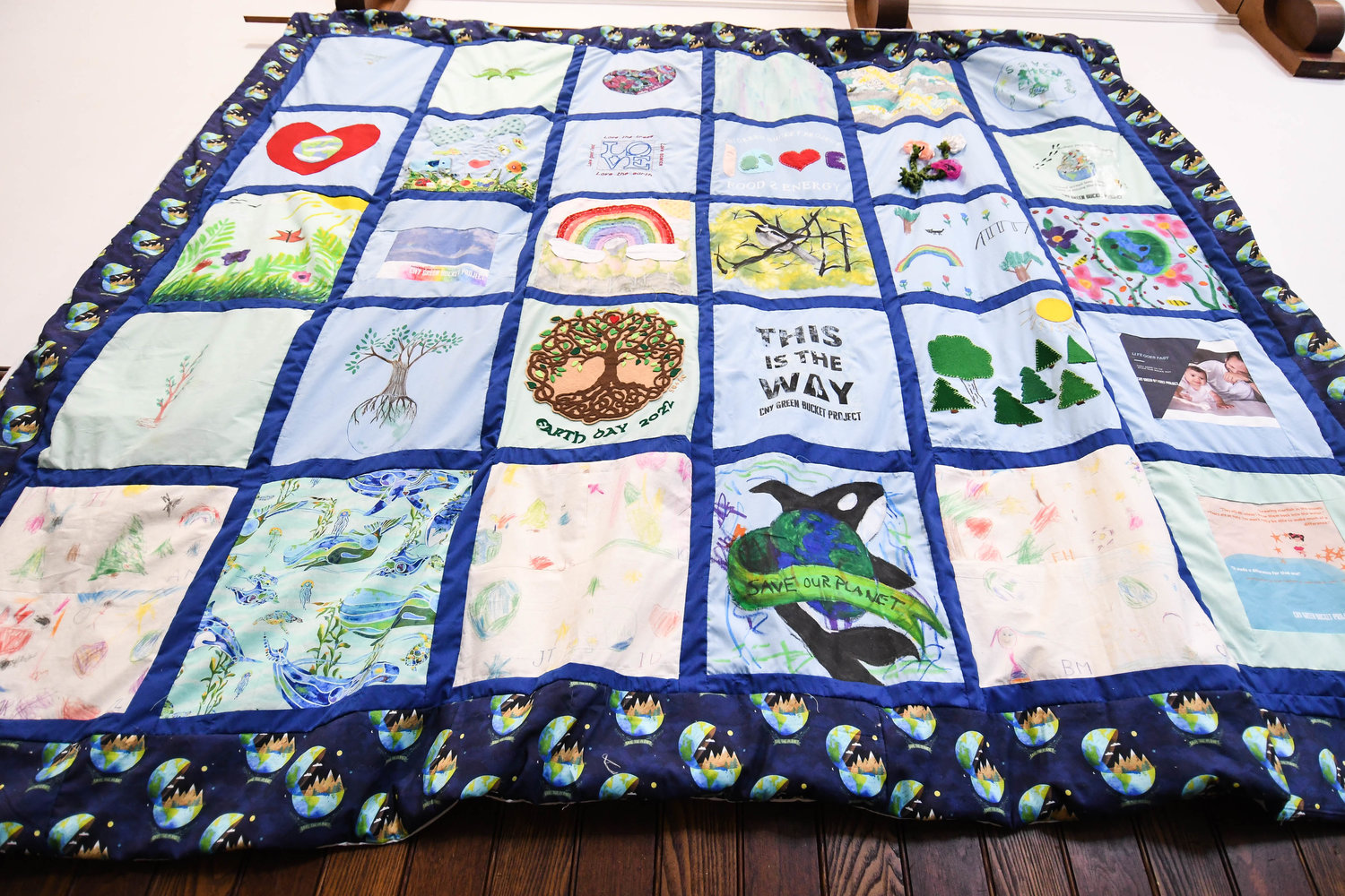 HELPING TO SAVE THE PLANET — This quilt is made of squares created by clients from the CNY Green Bucket Project, the only food scrap collection service.  Now the special quilt is on display on the second floor of Kirkland Town Library.