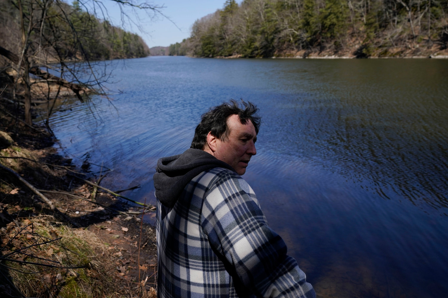 Michael Vallarella shows reporters a section of the Esopus Creek near his house in Saugerties, N.Y., Tuesday, April 5, 2022. As western regions contend with drier conditions, New York City is under fire for sometimes releasing hundreds of millions of gallons of water a day from the Ashokan reservoir in the Catskill Mountains. The occasional releases, often around storms, have been used to manage water the reservoir's  levels and to keep the water clear. But residents downstream say the periodic surges cause ecological harm along the lower Esopus Creek.  (AP Photo/Seth Wenig)