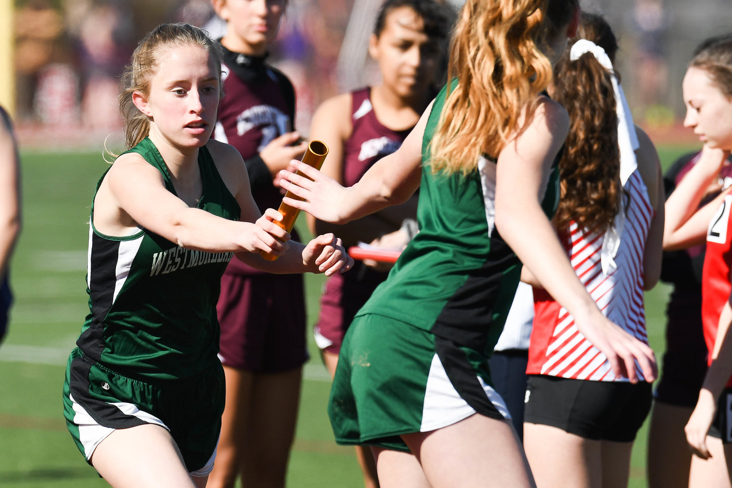 Westmoreland's Tessie Shafer, left, hands a baton off to teammate Emily Gubbins during the Cahill Classic on Friday at Sauquoit Valley High School.