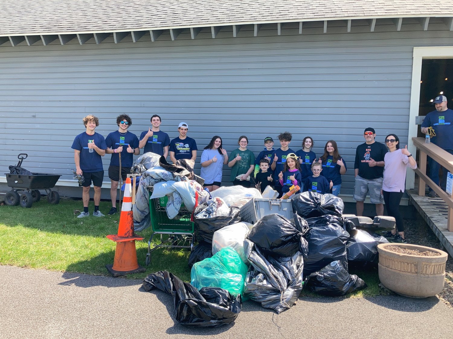 JOB WELL DONE — Volunteers with the Rome Canal Cleanup give a thumbs up for a job well done after they show off all the litter they cleared from Bellamy Park, the Erie Canal Trail and Mohawk River Trail during a special cleanup event Sunday.(Photo submitted)