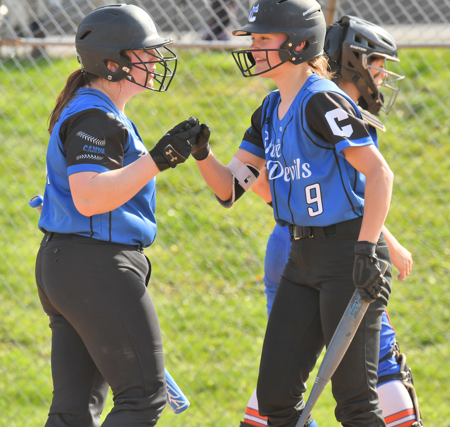 DEVILS STRIKE FIRST — Camden’s Kaitlyn Findlay, left, congratulates Brooke Musch after Musch scored the Blue Devils’ first run of the game Monday at Oneida. The Blue Devils won 9-6.