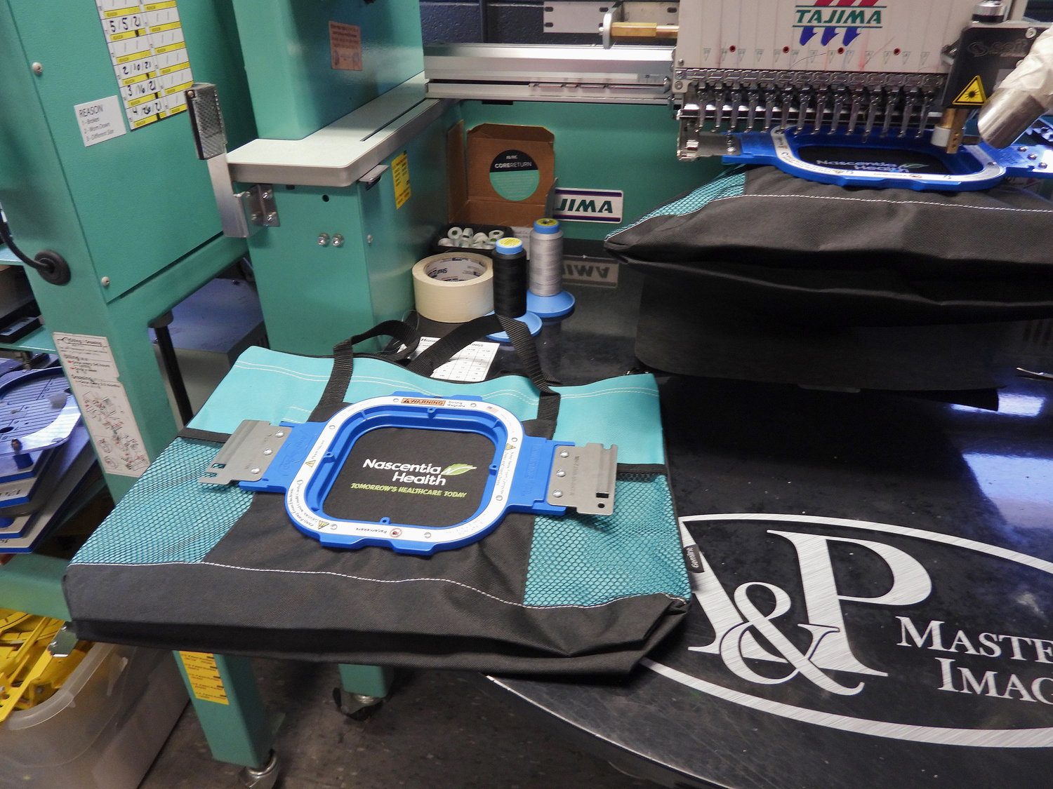 ALMOST READY — A custom bag for Nascentia Health is almost finished being embroidered at A&amp;P Master Images.