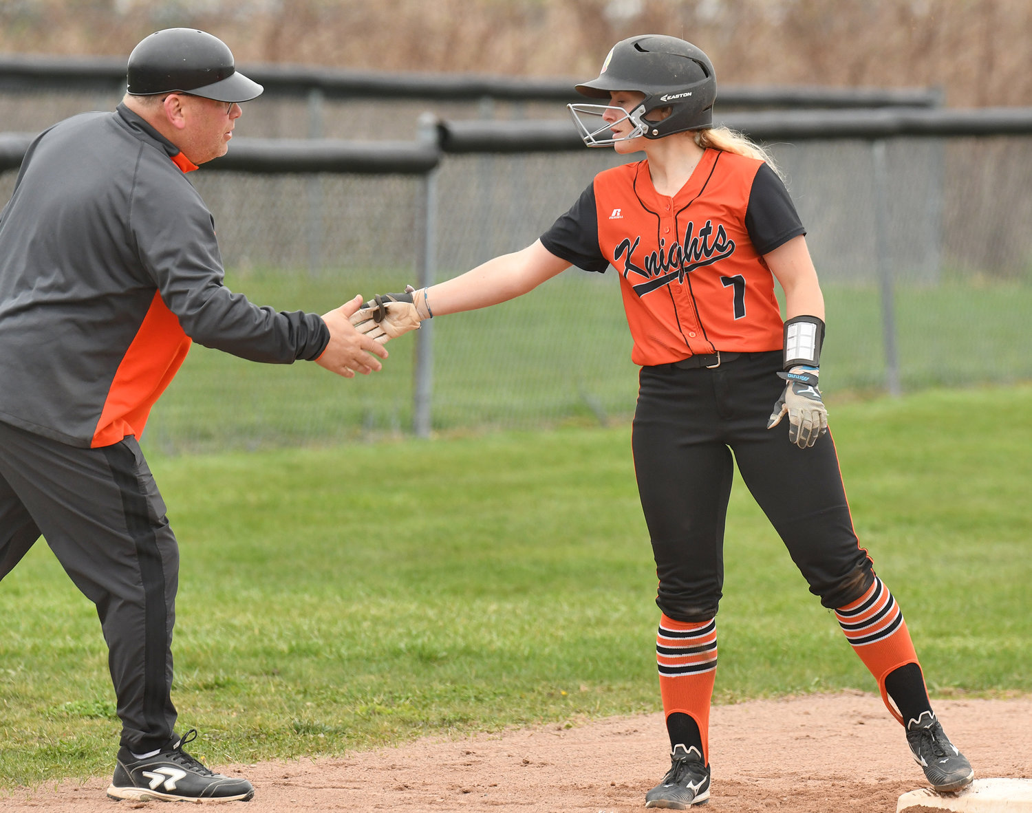 SMASH HIT — Rome Free Academy baserunner Lauren Dorfman gets congratulations from head coach Jerry Closinski after hitting a triple in the first game of the team's doubleheader sweep at home at Kost Field over Utica Proctor. Dorfman singled twice, doubled, tripled and scored four runs.