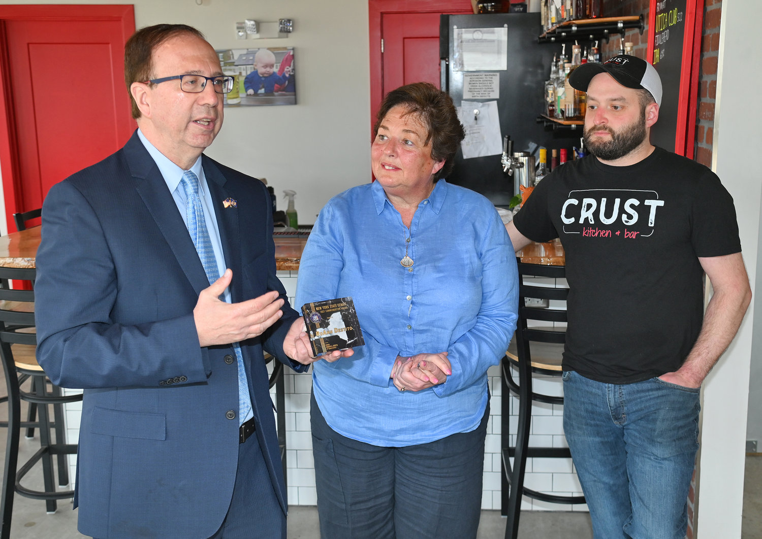 HONORED — State Sen. Joseph A. Griffo, R-47, Rome, presents a New York State Senate Commendation to RoAnn Destito, center, while her son, Christopher Destito, looks on. The commendation, presented in a ceremony at the Crust Kitchen and Bar, 86 Hangar Road West, honors the former assemblywoman and Office of General Services commissioner for her longtime career in public service.