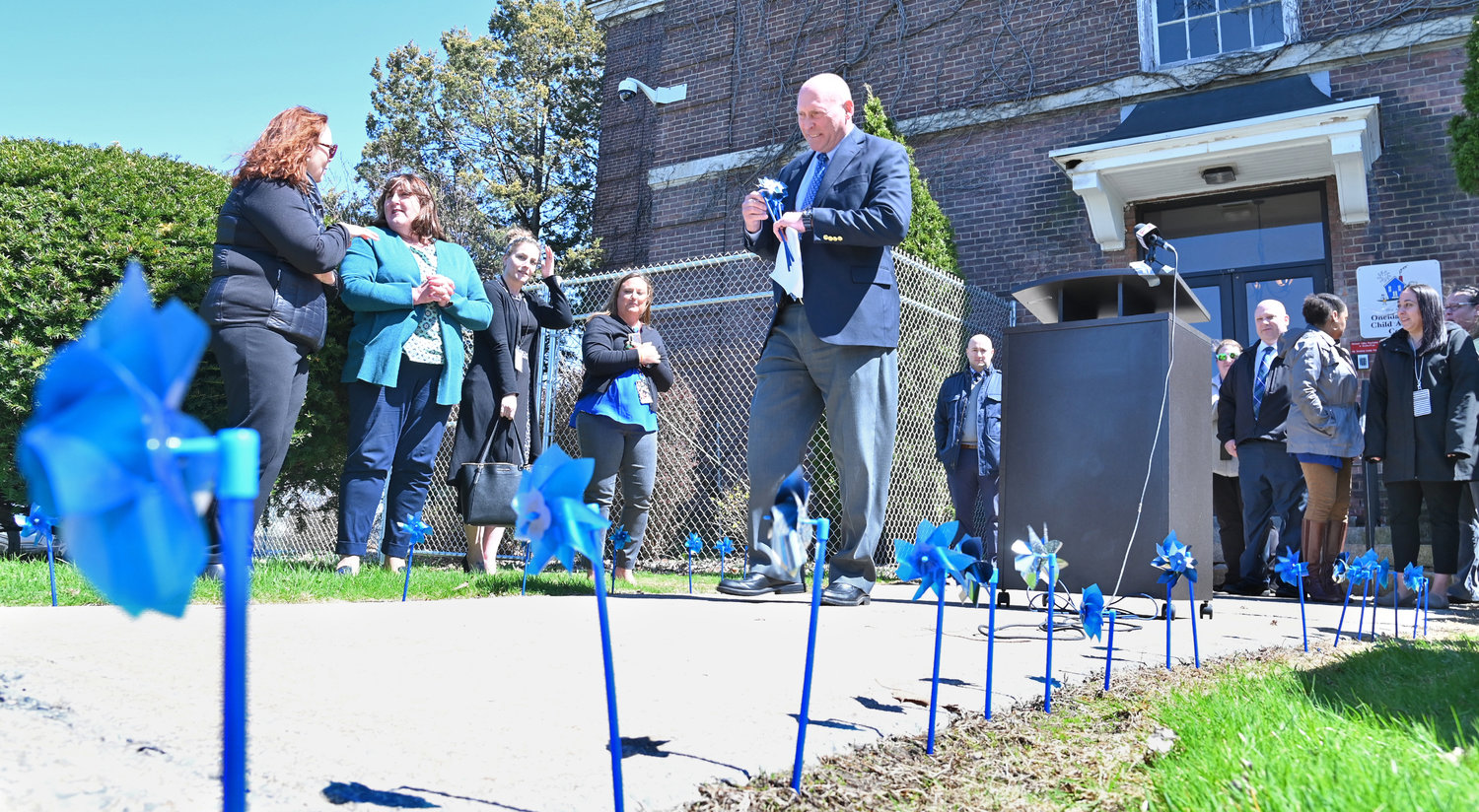WINDY DAY — Blue and white pinwheels spin in the wind outside the Oneida County Child Advocacy Center in Utica on Thursday. County leaders take time every April to spread awareness of the facility’s work, placing pinwheels in the ground as a symbol.